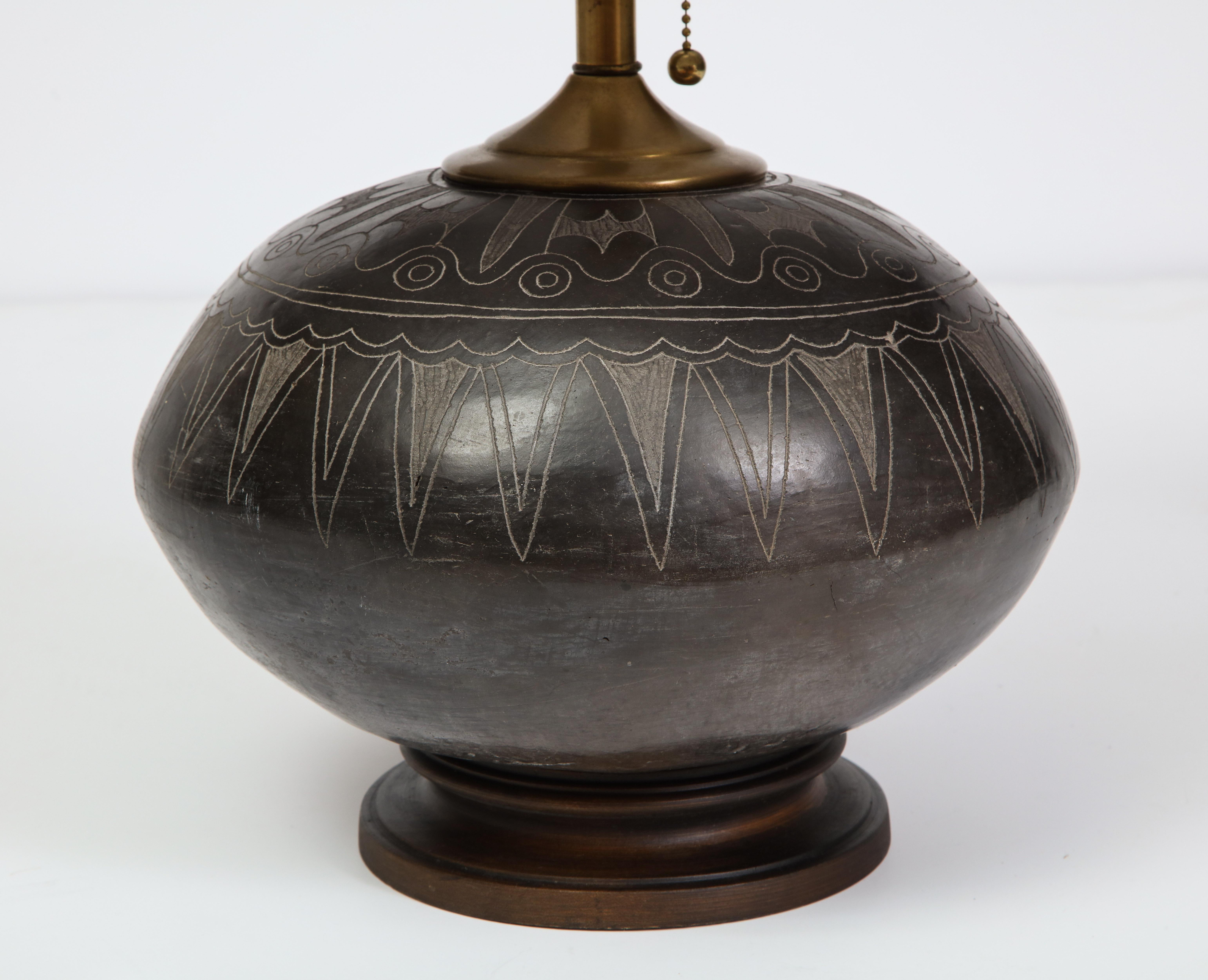 Hand carved Peruvian pottery table lamp from the 19th century, with a new pleated silk shade and natural stone finial. The pottery base is in impeccable condition for its age. Shade is 14