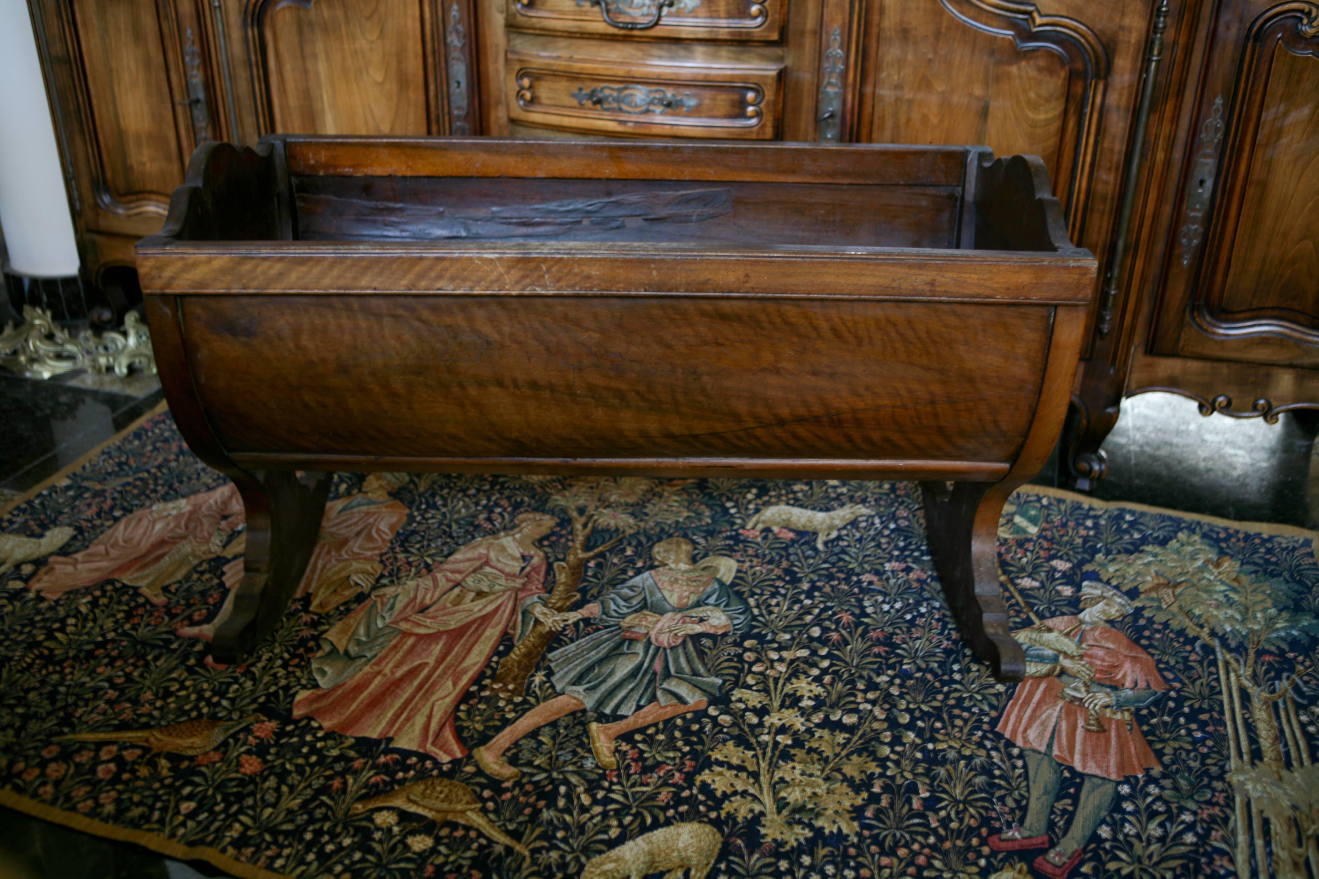 19th century hand-carved cradle made of dark walnut that rests on two scrolled rockers. 
Very good condition, 
France, circa 1870.