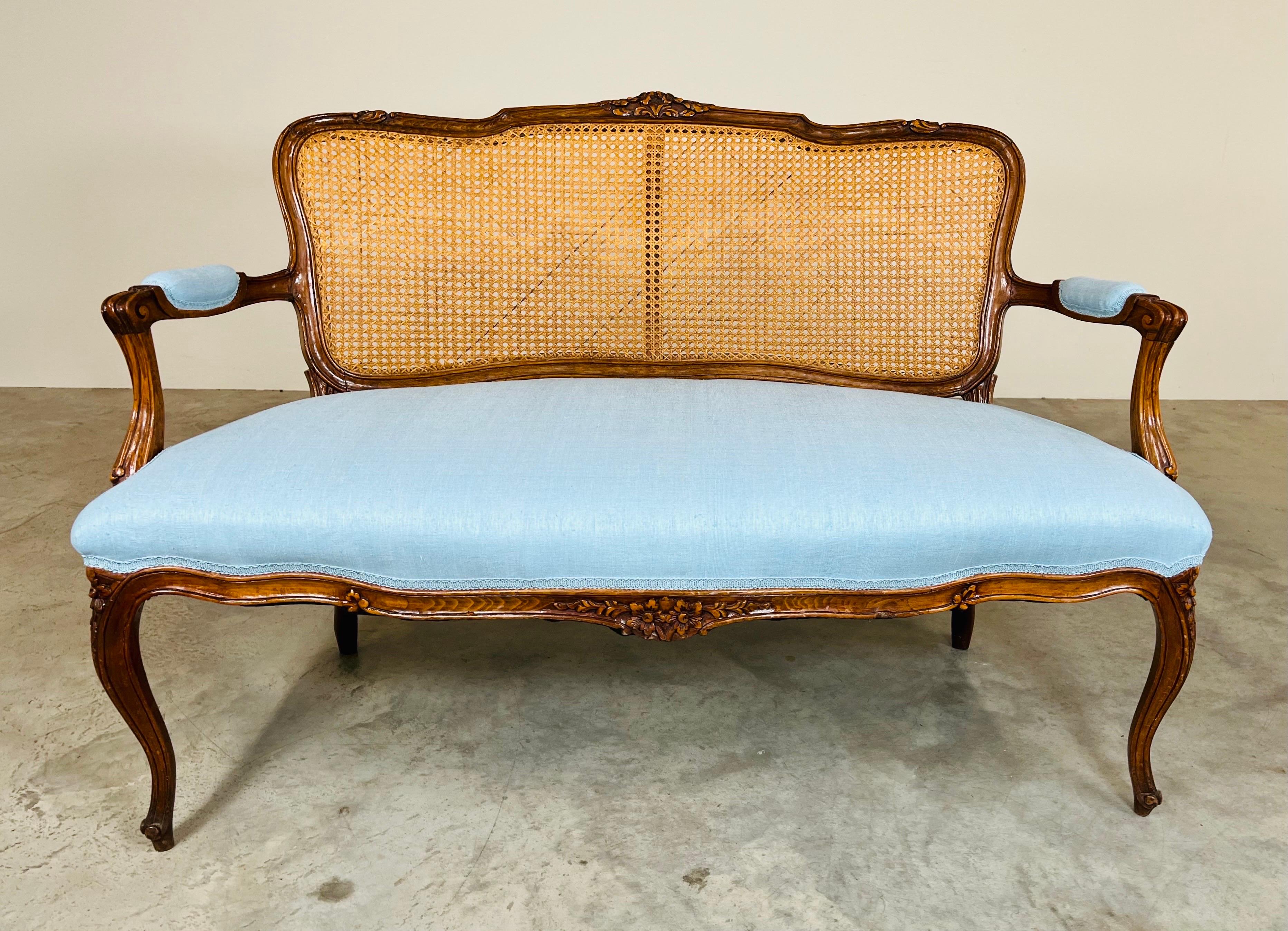 An absolutely beautiful late 19th century settee having hand carved walnut frame with floral and leaf details newly cushioned and upholstered in silk linen new old stock material. France circa 1880. Acquired from the personal collection of a