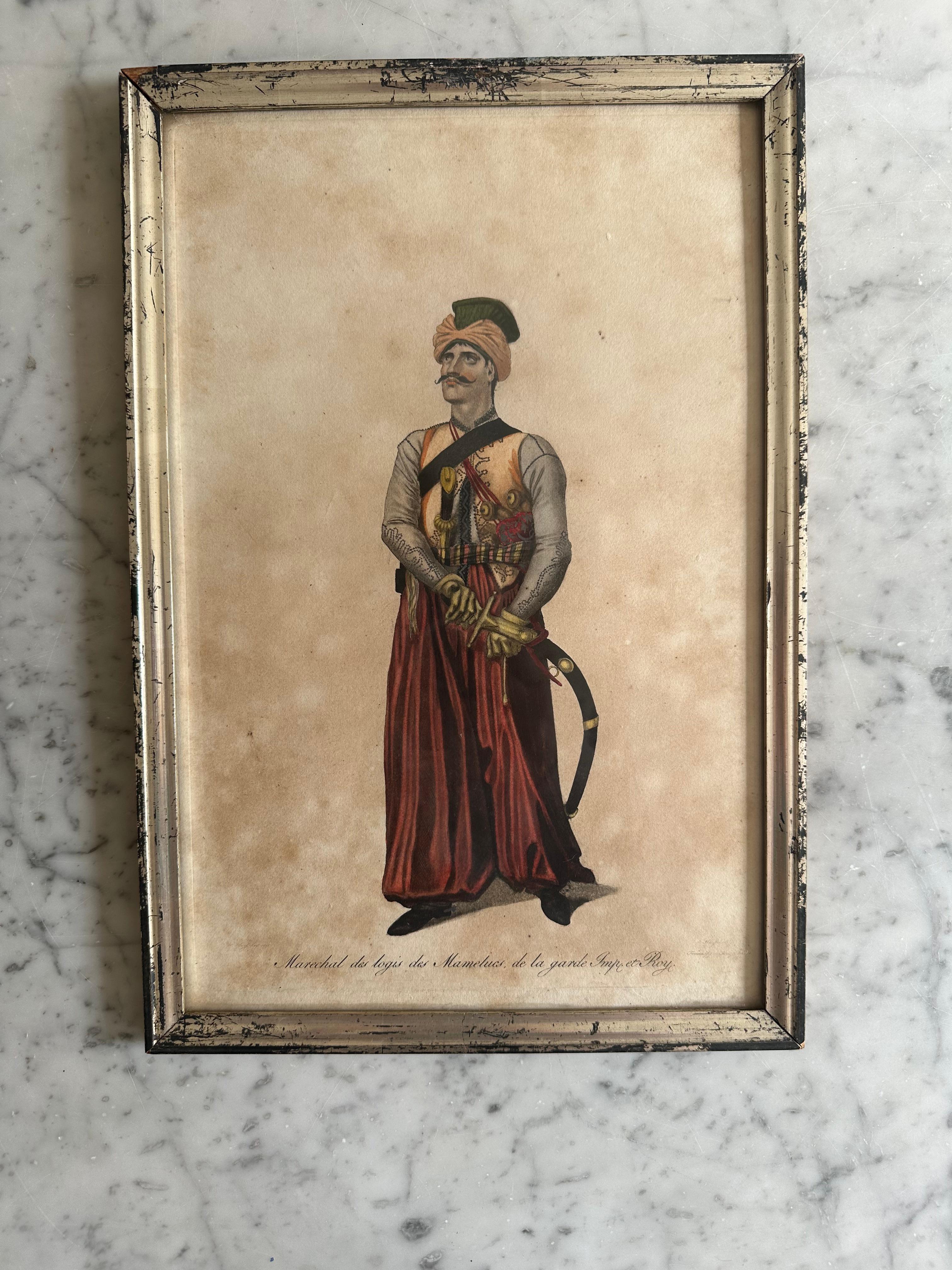 This striking 19th-century hand-colored copper engraving depicts a detailed portrait of an Arab armed warrior, complete with a French subtitle specifying his exact designation. The craftsmanship is exceptional, with vibrant hand-applied colors that