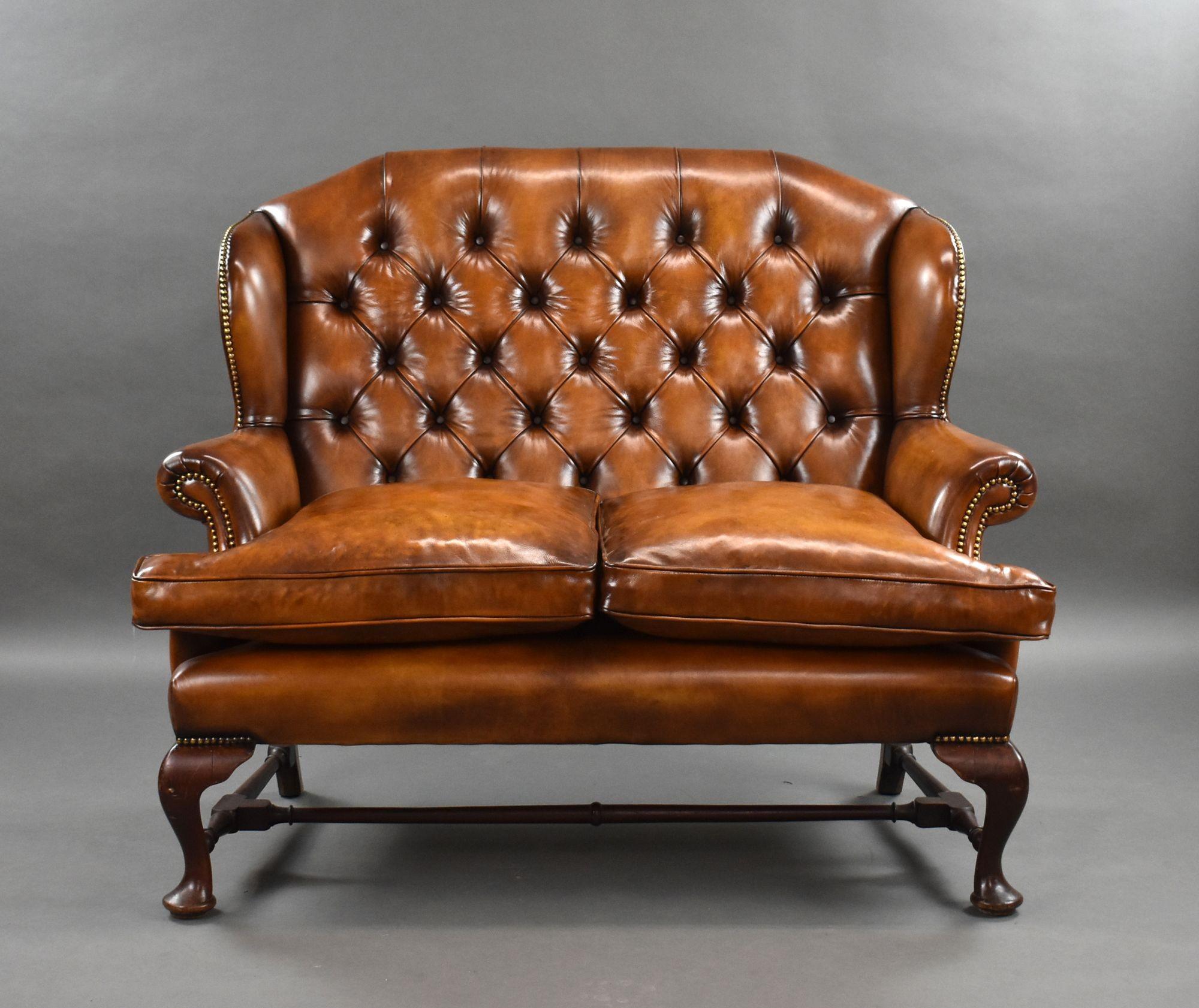 For sale is a good quality 19th century hand dyed leather wing back sofa, having a deep buttoned back, flanked by two wings above two feather stuffed cushions. The sofa stands on elegant cabriole legs united by a stretcher. The sofa is upholstered