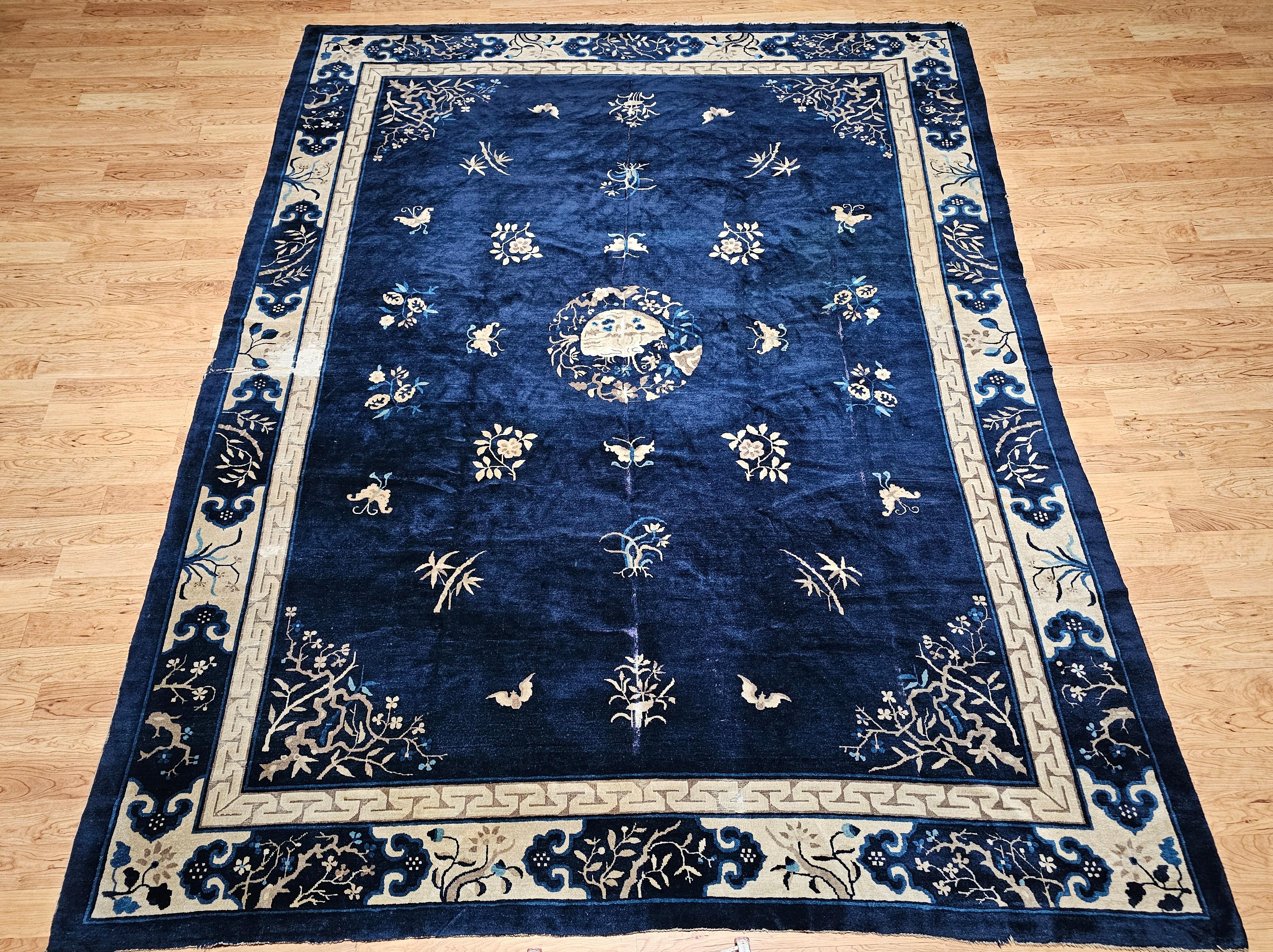 A graceful 19th-century Chinese Peking rug in a near-square room size format, featuring a deep navy blue field woven from vibrant, lustrous wool. The elegant ivory border frames the composition with a refined floral design, accented in French blue,