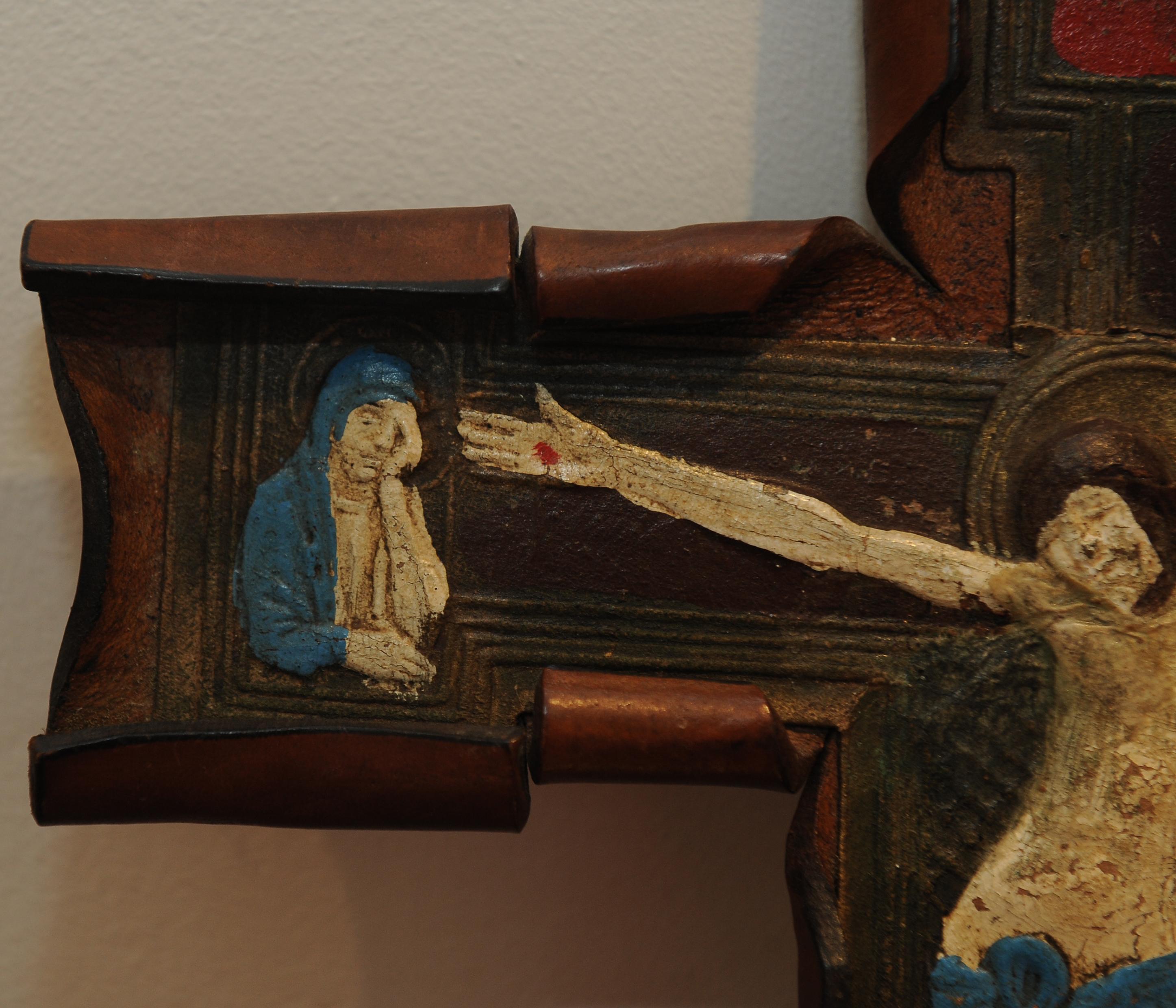 19th Century Hand Made Leather Folk Art Crucifix Featuring A Hand Painted Depiction of Jesus Upon The Cross With A Mourning Joseph & Mary.  

A Hand Made Hand Painted Folk Art Decorative Item, to Grace Your Wall. 