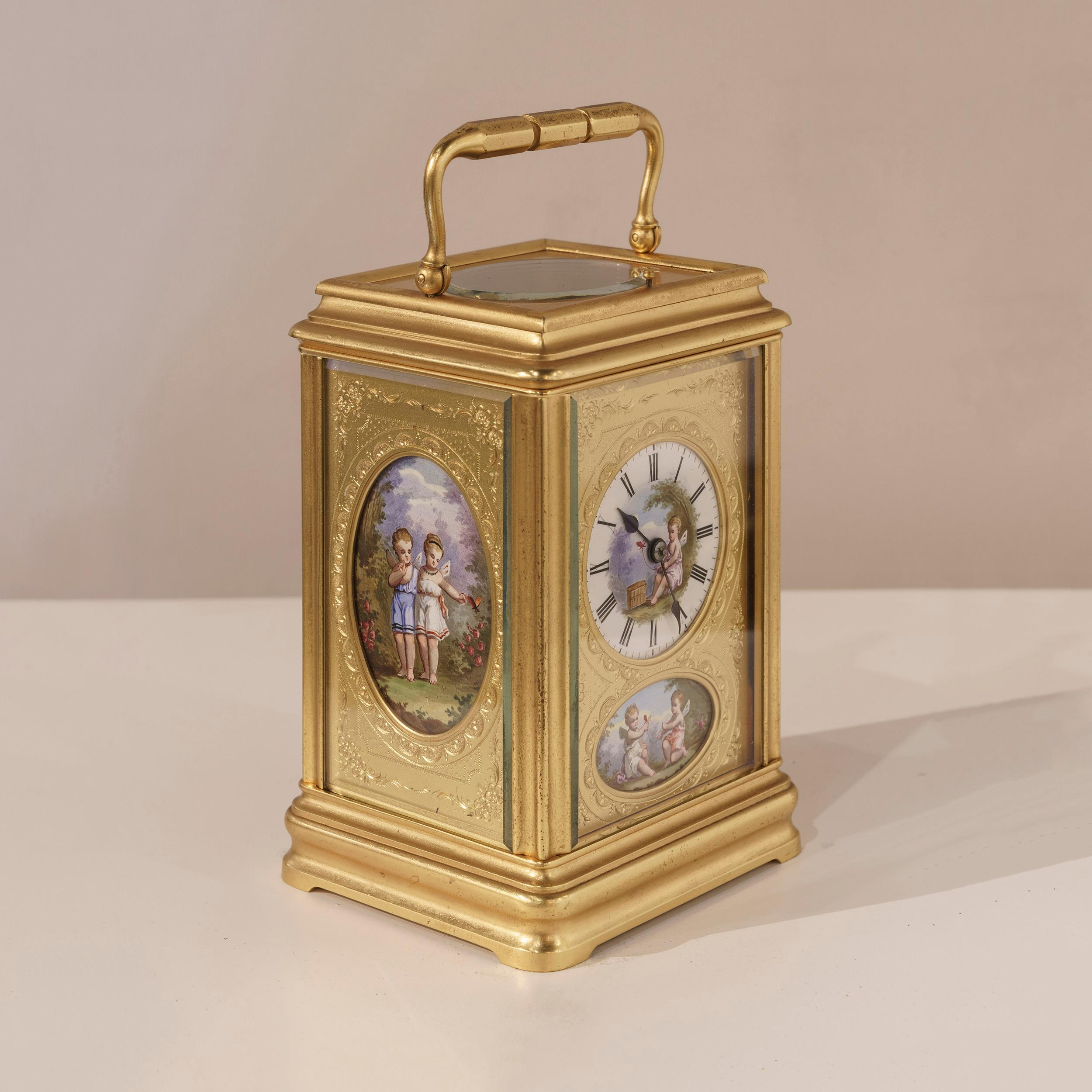 A fine carriage clock

The engraved gilt case rises from an ogee plinth, and is dressed with elliptical polychrome enameled plaques to the fascia and the sides, depicting children in a Romantic setting, with a carrying handle atop, set across the