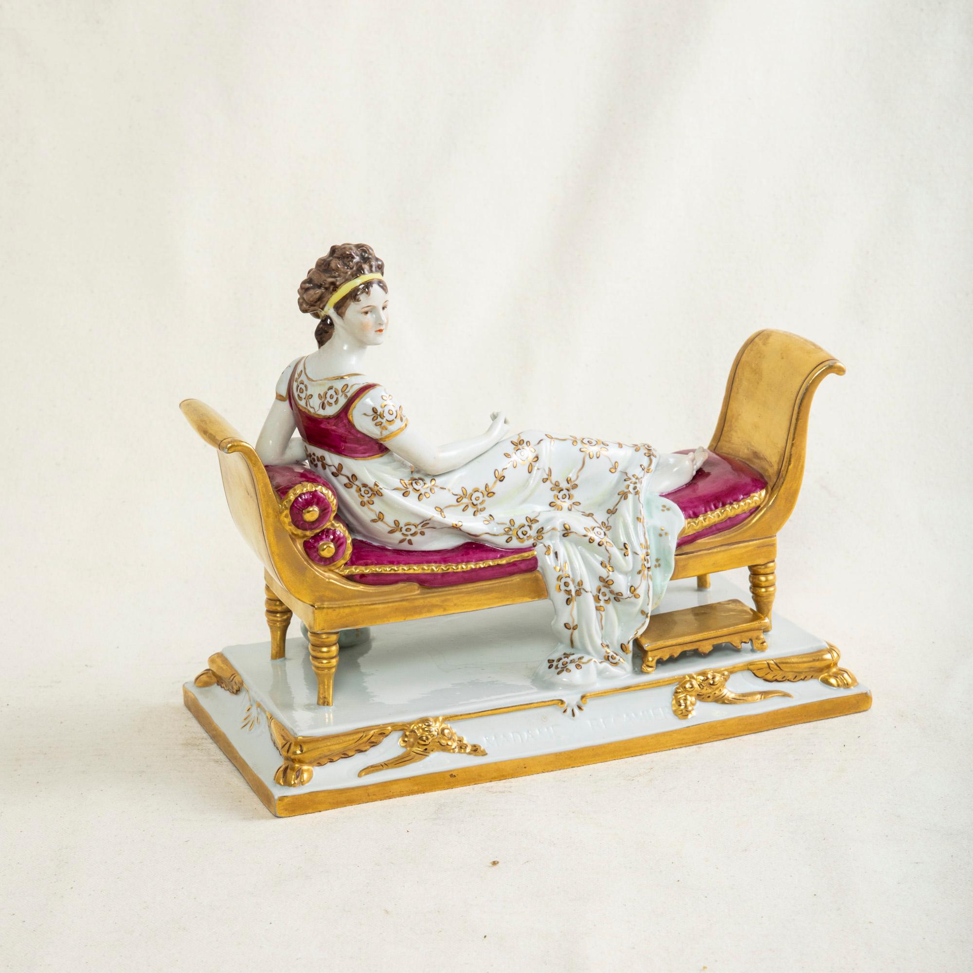 Cette figurine en porcelaine française de la fin du XIXe siècle représente Madame Récamier au repos sur un lit de repos doré. Juliette Récamier (1777-1849) était une mondaine célèbre au début du XIXe siècle, connue pour sa beauté ainsi que pour ses