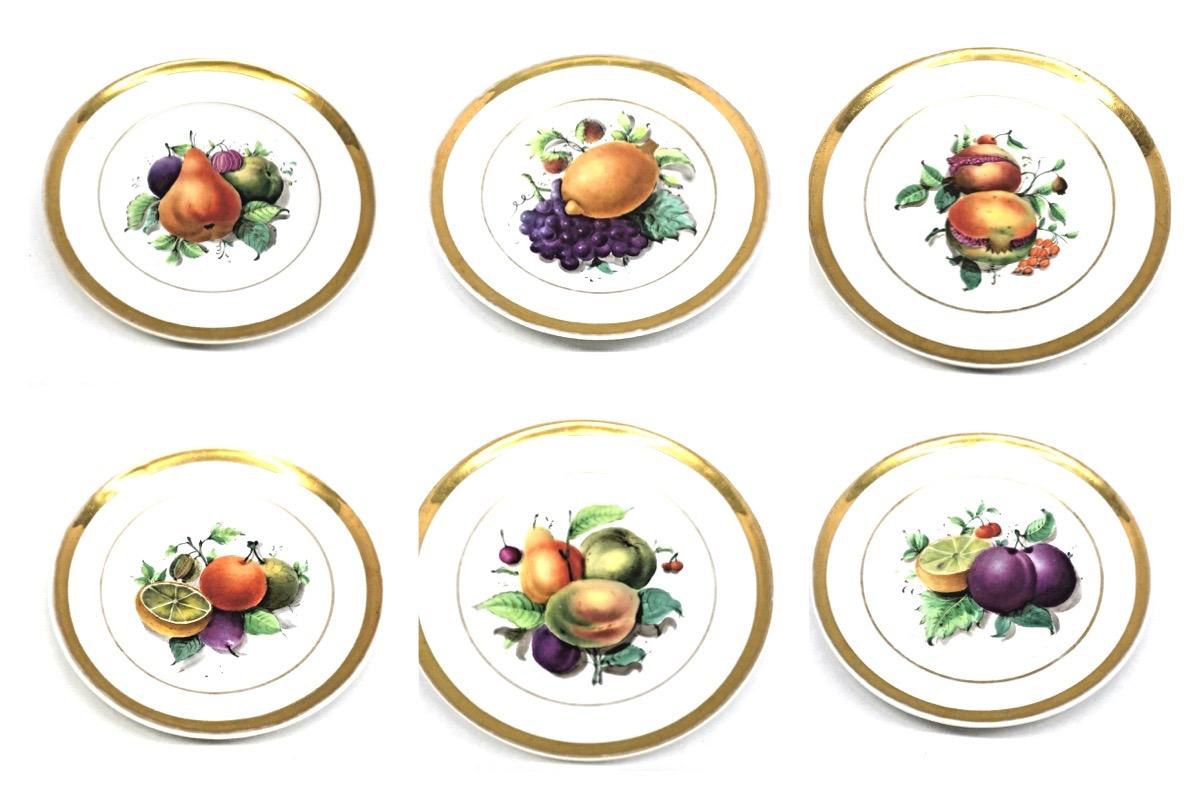 A set of six porcelain Fruit still life themed plates, made in Thuringia, Germany, circa 1860s. 
Central images show a hand painted still life pattern of brightly colored fruits, encircled by banded rims in gold. This is a set of six different