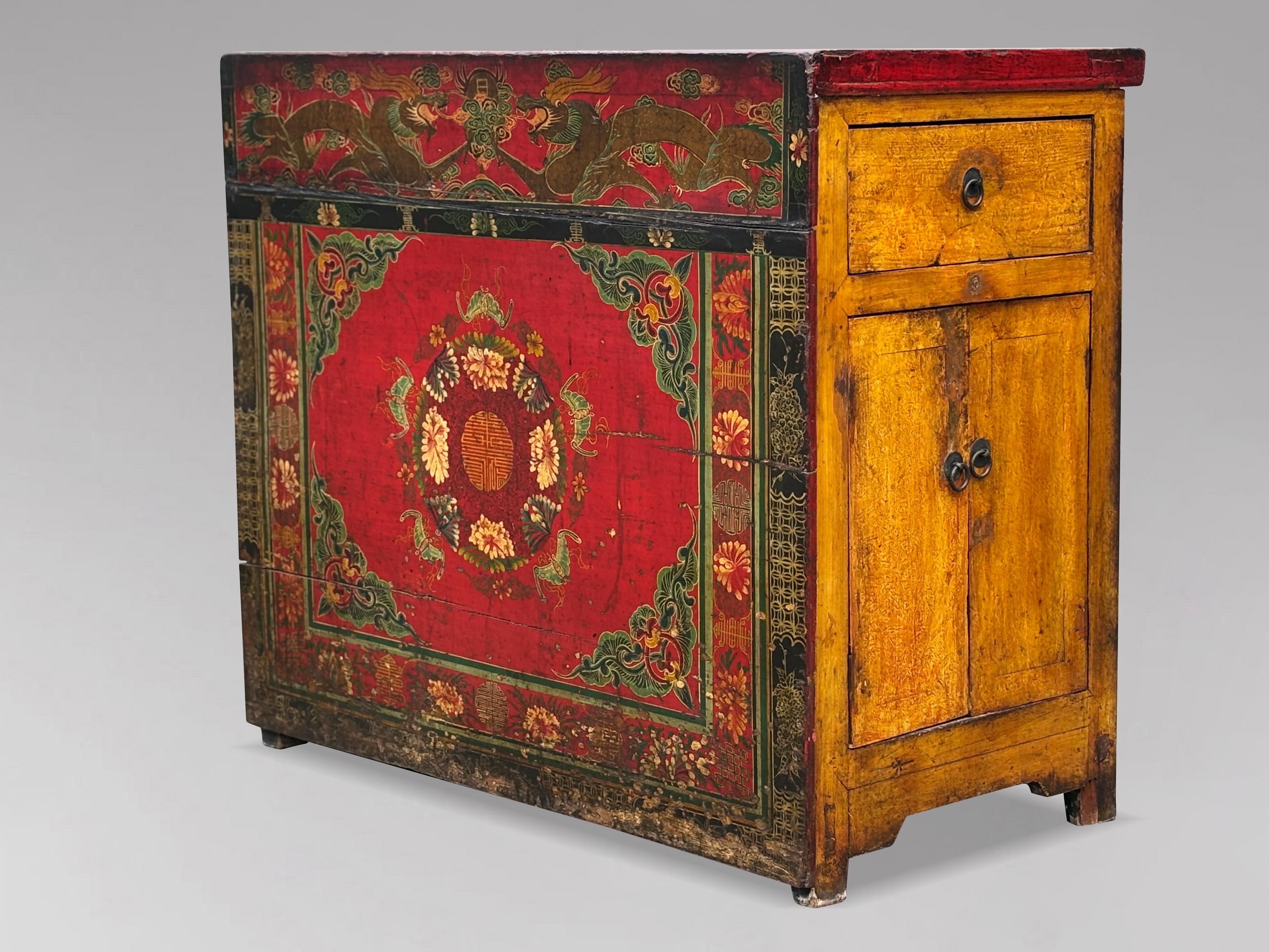 Cette armoire tibétaine du Gansu, peinte à la main à la fin du XIXe siècle, présente une façade ornée de représentations complexes de fleurs mystiques et de dragons, complétées par des motifs décoratifs sur l'ensemble de la surface. Avec sa