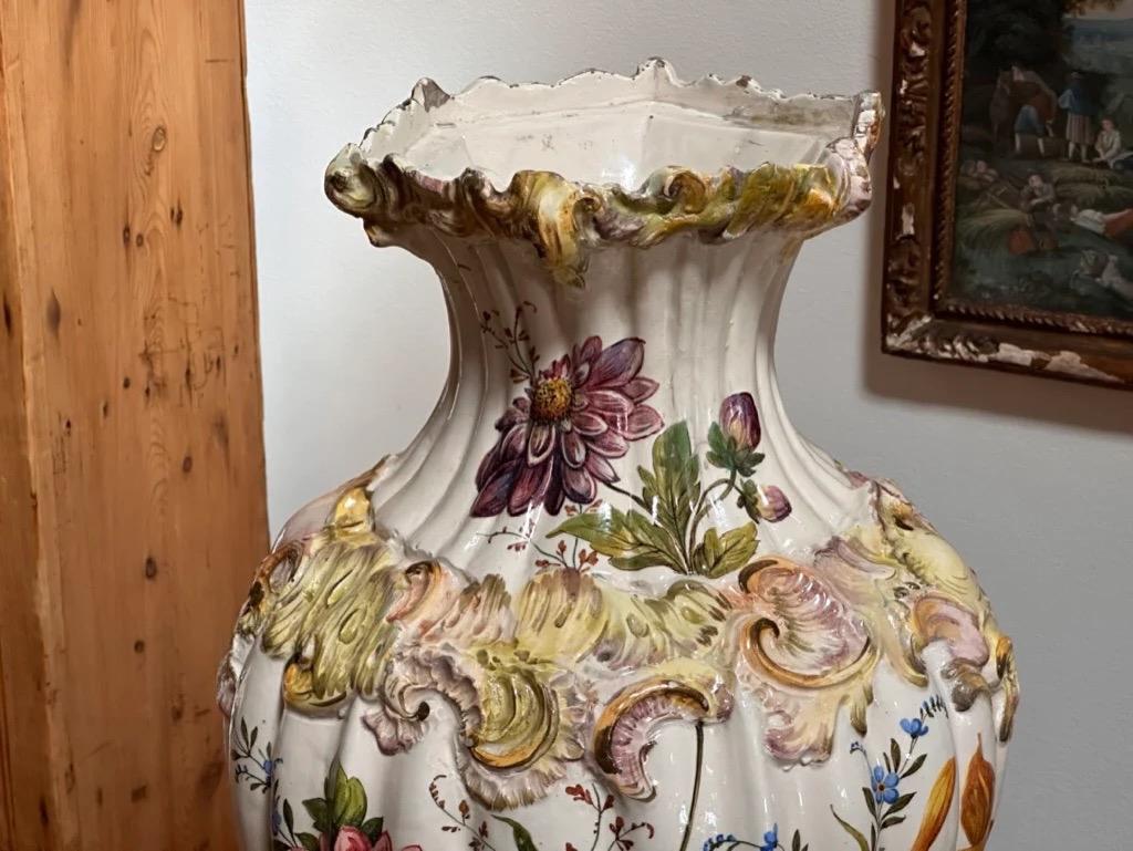 Hand-painted Italian Faience Vase and separate stand, Nove, marked, 19th century, hexagonal rim above a fluted body with molded foliage and polychrome enamel decorated with flowers, 22 ¾” h x 12” w.
