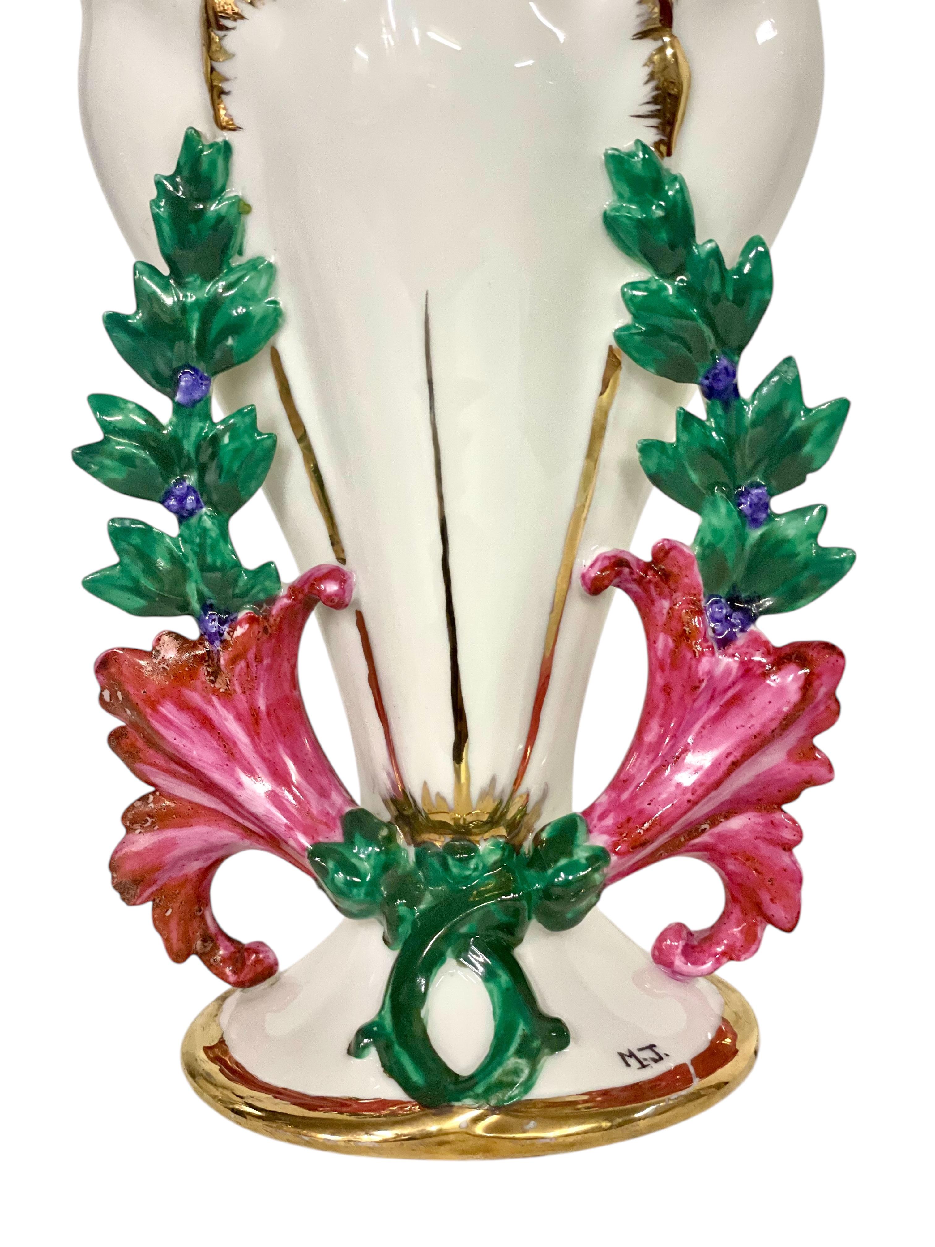 Questo squisito vaso a cornucopia in porcellana del XIX secolo è un esempio lampante dei disegni romantici e ornamentali tipici dell'epoca. La sua forma scanalata e la decorazione elaborata riflettono un'eleganza senza tempo, ideale per commemorare