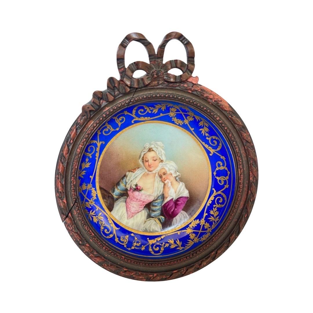 Une exquise plaque circulaire en porcelaine du XIXe siècle, finement peinte à la main et signée par Félicie Palade Bonnal, une portraitiste française renommée, célèbre pour ses miniatures délicates aux résonances émotionnelles. La scène centrale