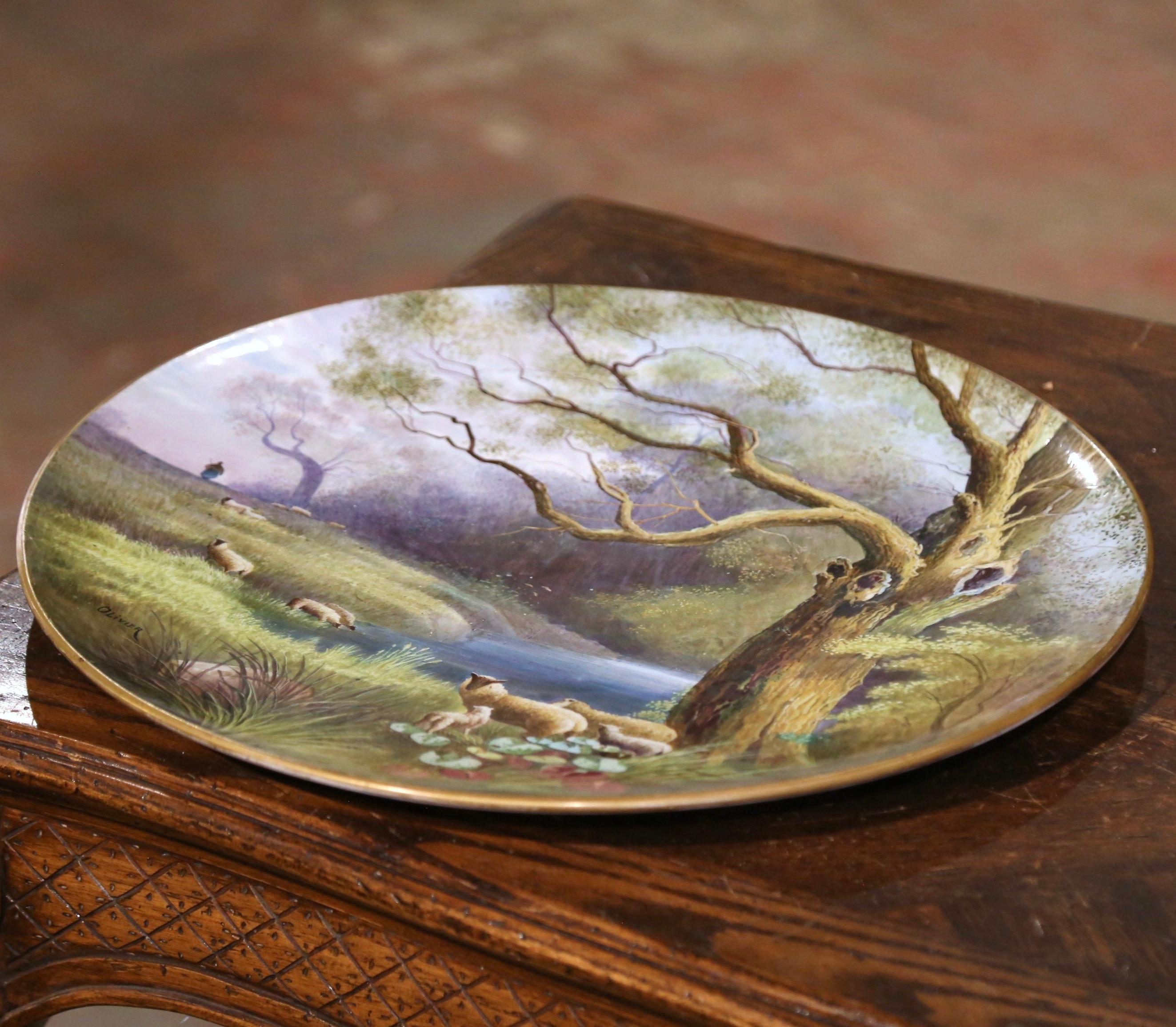 Decorate a kitchen wall, a breakfast room or a restaurant with this large and colorful antique platter. Crafted in France circa 1870 and round in shape, the charming hand painted porcelain plate features a country landscape scene with sheep grazing