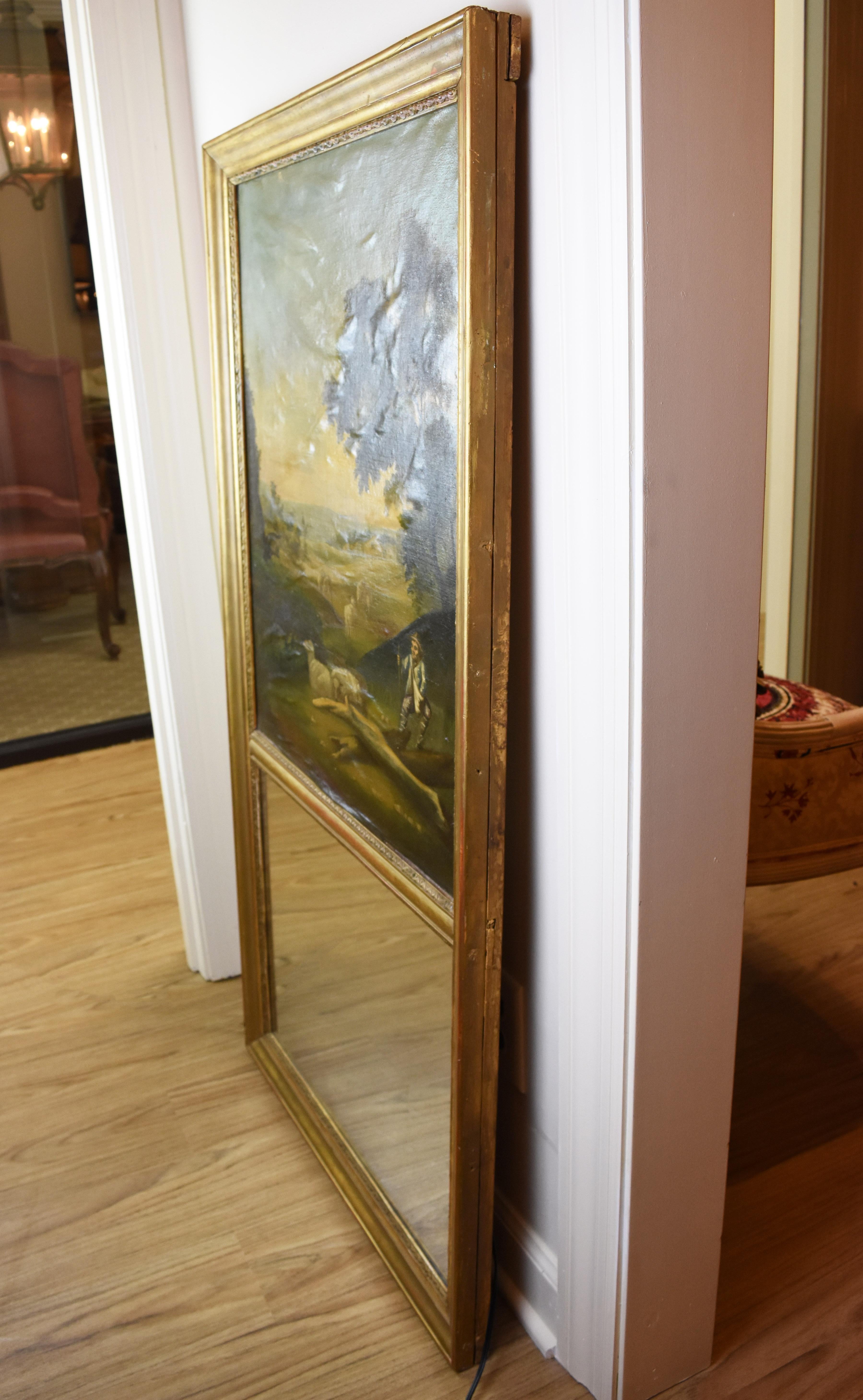 This early 19th century hand-painted Trumeau Mirror features a lovely landscape scene. Both the mirror and the oil painting sit vertically in a simple giltwood frame. There has been some stretching to the canvas such that there are minor wrinkles as