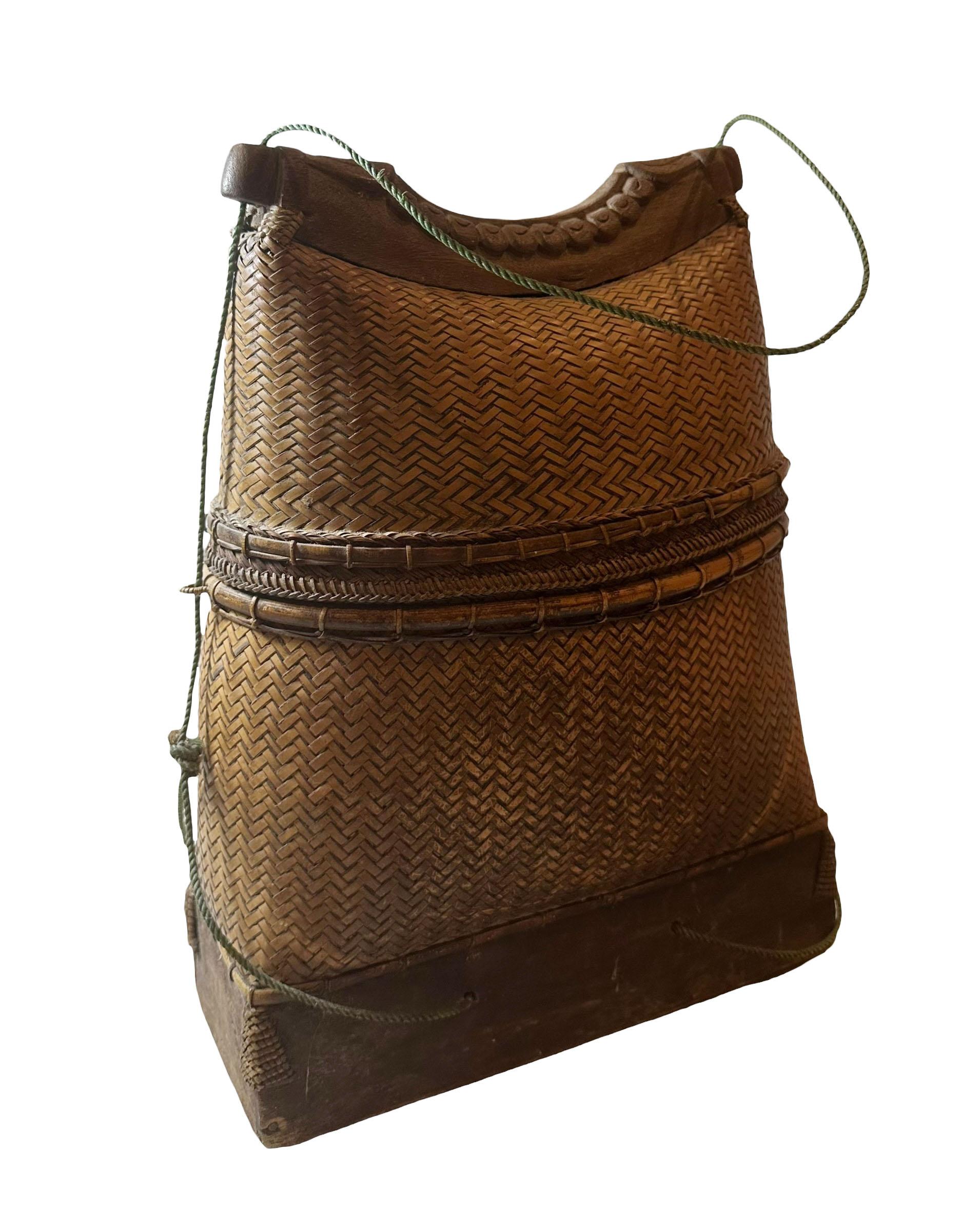 This basket is from the Philippines and date from late 19th century to 1905. It is beautifully hand woven and in superb condition. The handle at the top is carved, no particular pattern. 