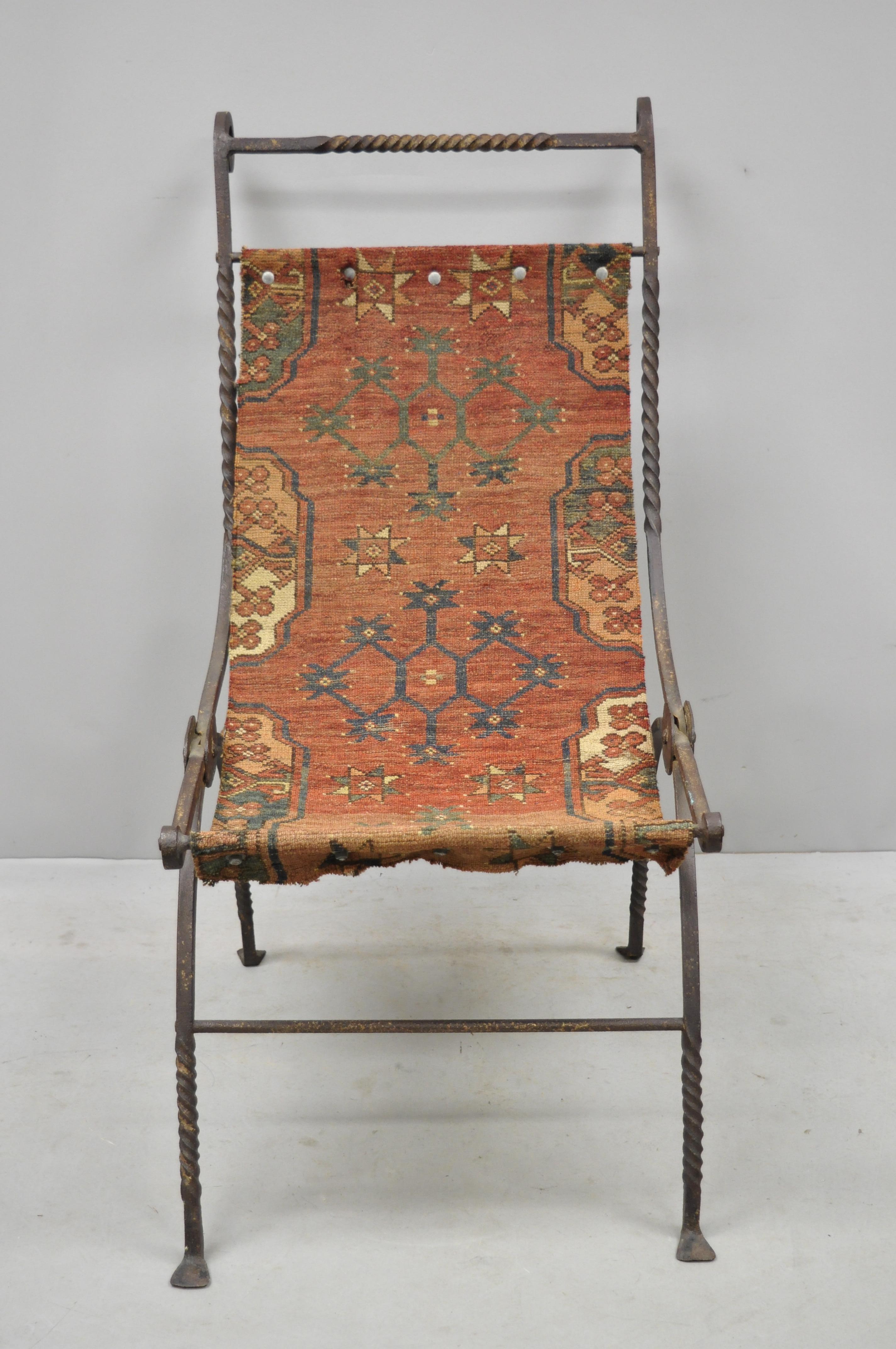 19th century hand wrought iron Renaissance Savonarola carpet sling side chair. Item features hand wrought iron folding frame, desirable weathered finish, carpet 