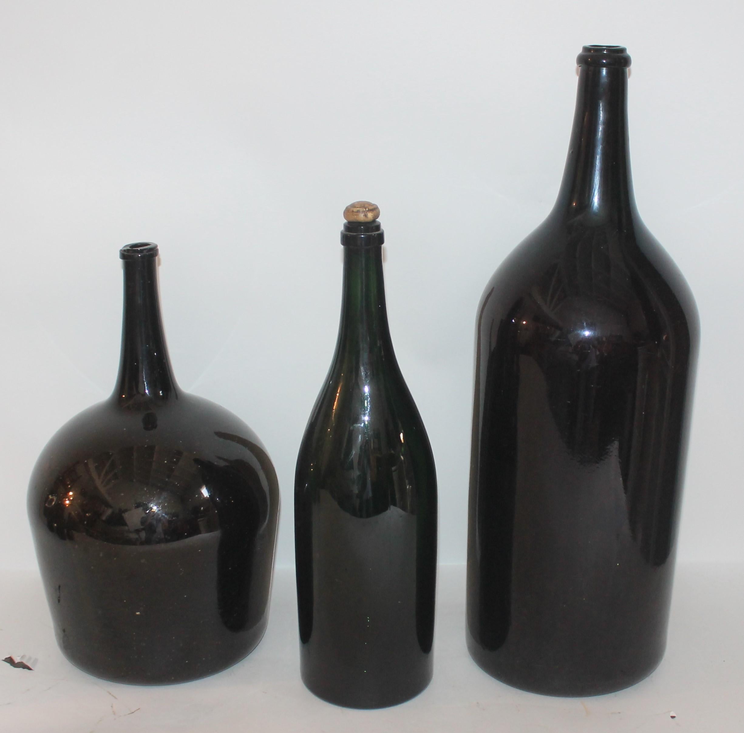 This group of three, early 19th century handblown olive green bottles are all handblown and in pristine condition. Most likely used for wine. Fantastic colors and full of bottles. Sold as a set of three.


Measures: Large bottle-28 x 7
Tall thin