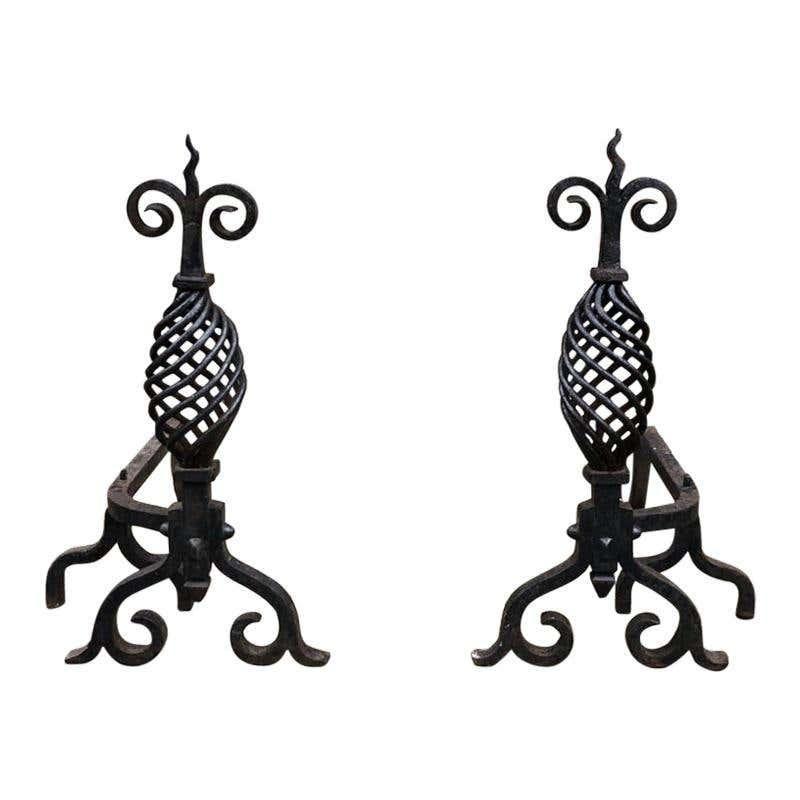 A large pair of 19th century handwrought iron Gothic fireplace andirons firedogs. This pair are completely wrought by hand out of very thick iron and have a dark black finish, crafted with swirled legs and shafts with beautifully wrought floral
