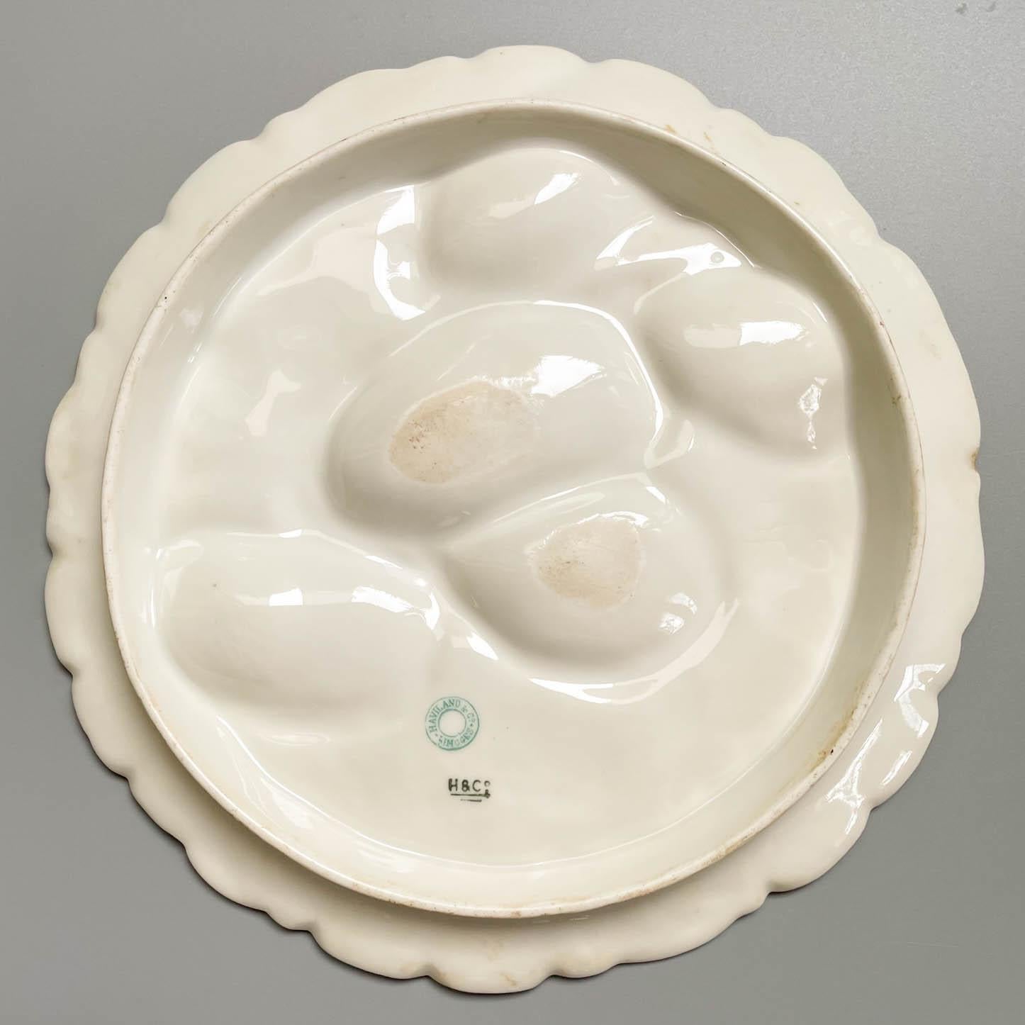 A 19th Century French turkey oyster porcelain plate with five white wells on raspberry pink ground. Decorated with delicate hand-painted gilt branches and gilt trimmed ruffled rim. Mark on back: Haviland & Co. Limoges. Circa 1880-1900. Dimensions: