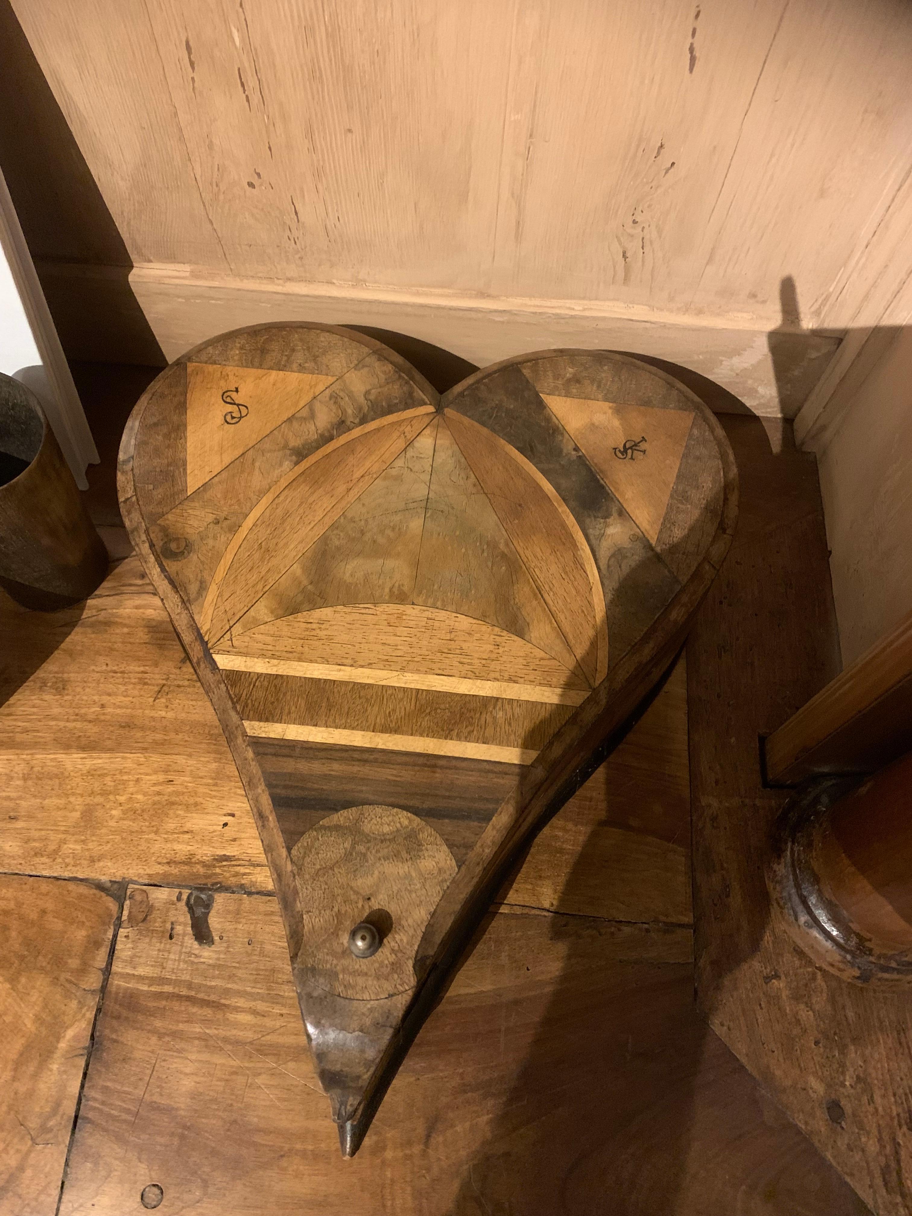 Une magnifique boîte en bois en forme de cœur avec une fine incrustation intarsia de différentes essences de bois et de monogrammes. Probablement Italie, XIXe siècle. La vie est comme une boîte de chocolats.