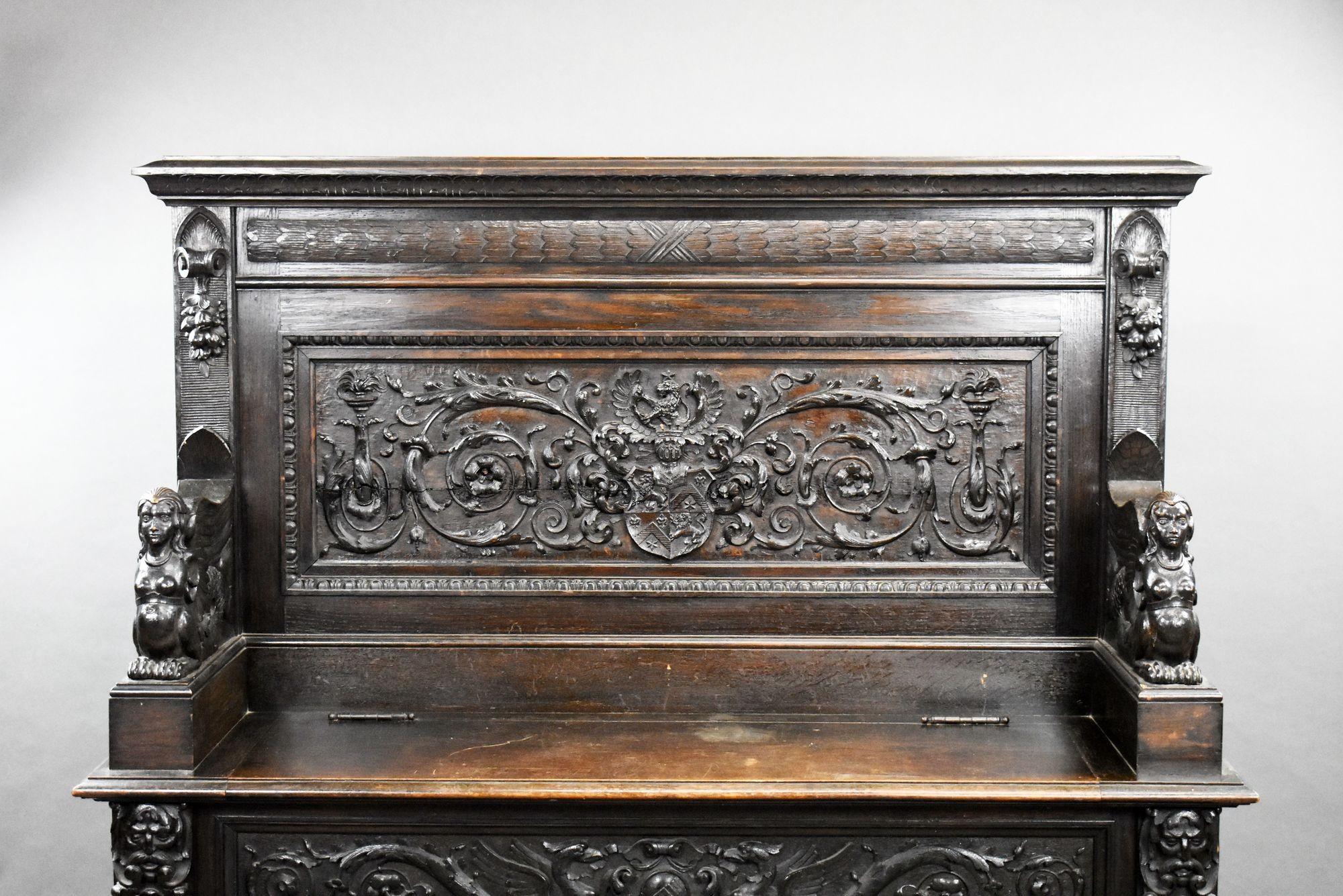 For sale is a very good quality 19th century continental heavily carved oak settle, with a scroll carved panel back and flanking carved mythical beasts to the arms, with a hinged seat on a conforming frieze and projecting feet. This piece remains in