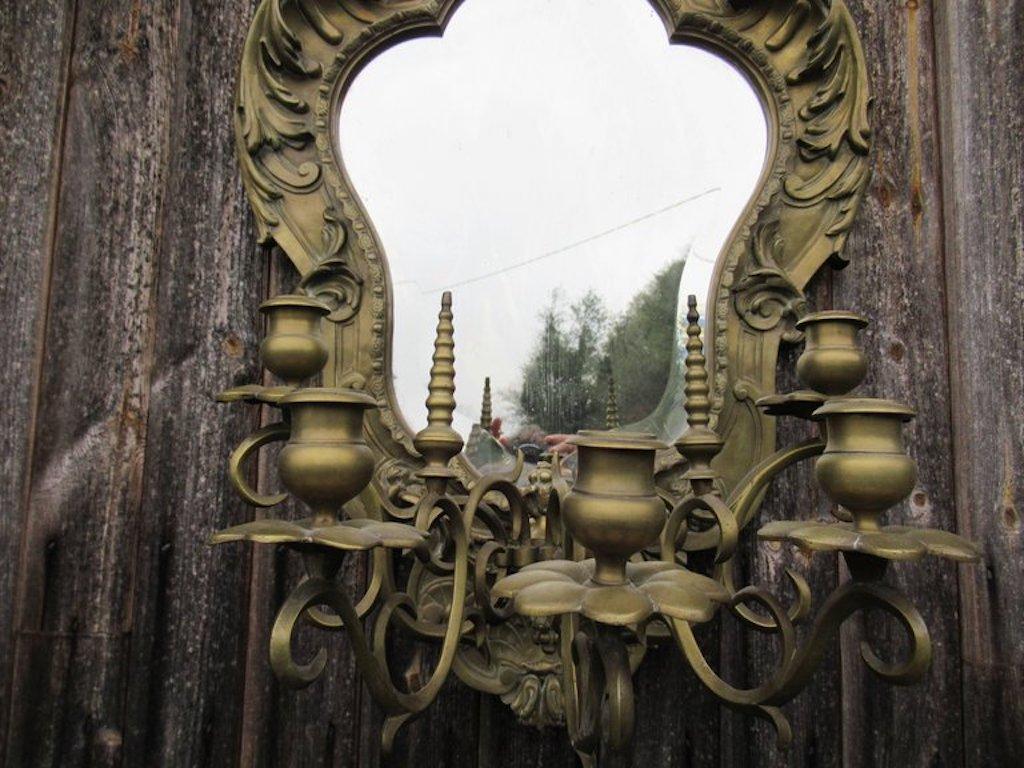 A 19th century heavy gilt brass mirror with five branch candelabra, the central foliate pediment flanked by scrolled leaf decoration with tapered rib finials height 73.5 cm 29 inches with 48 cm 19 inches depth 34 cm 13 inches £1500.