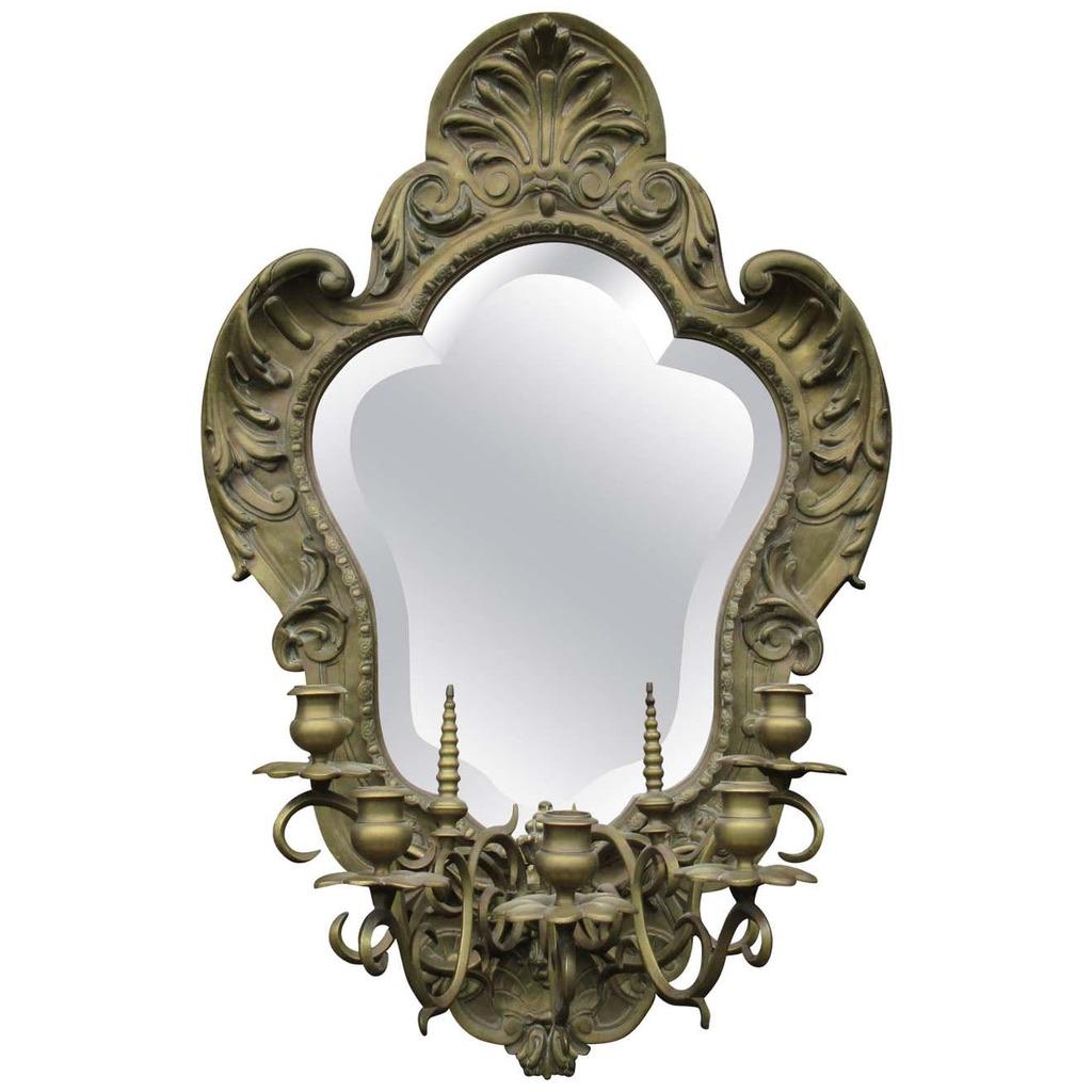 Specchio in ottone dorato del XIX secolo con candelabro a cinque rami, con frontone centrale a fogliame affiancato da decorazioni a fogliame con nervature affusolate.
 