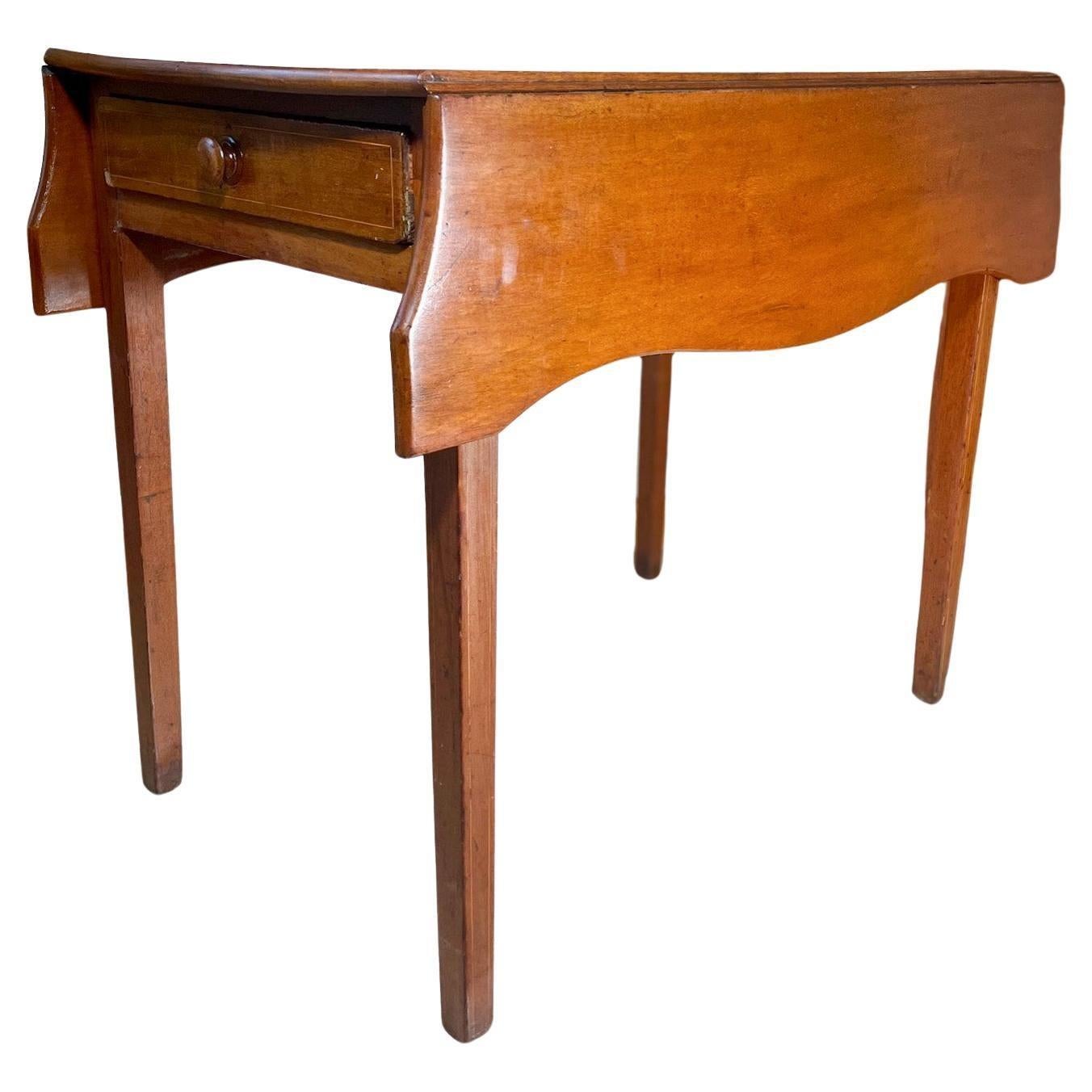 English Hepplewhite Dropleaf Pembroke Side Table.

This early 19th Century dropleaf table with drawer lifts on both sides with butterfly leaf brackets.  A uniquely stylized square tabletop, it stands on four tapered legs highlighted with pinstriping