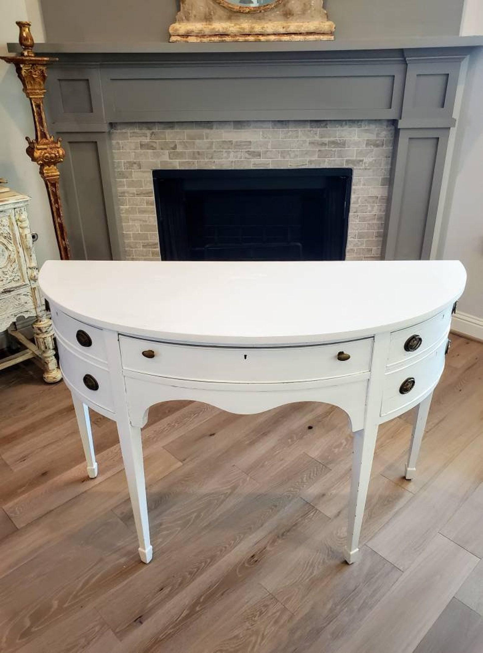 An elegant late 19th century mahogany sideboard, finished in Hepplewhite taste, with later distressed painted white finish. 

Finely hand-crafted of mahogany solid woods, bow front demilune shaped, having a single drawer crafted of high quality