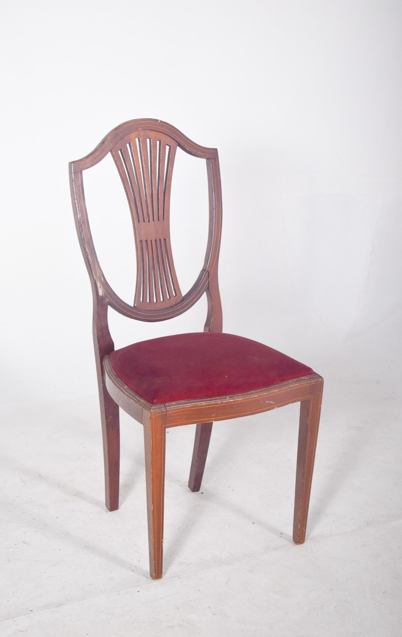 Sedia in stile Hepplewhite con imbottitura rossa. Con uno schienale a forma di scudo, una caratteristica sorprendente dello stile Hepplewhite, popolare in Inghilterra alla fine del XVIII secolo. Lo schienale è composto da doghe verticali curve che
