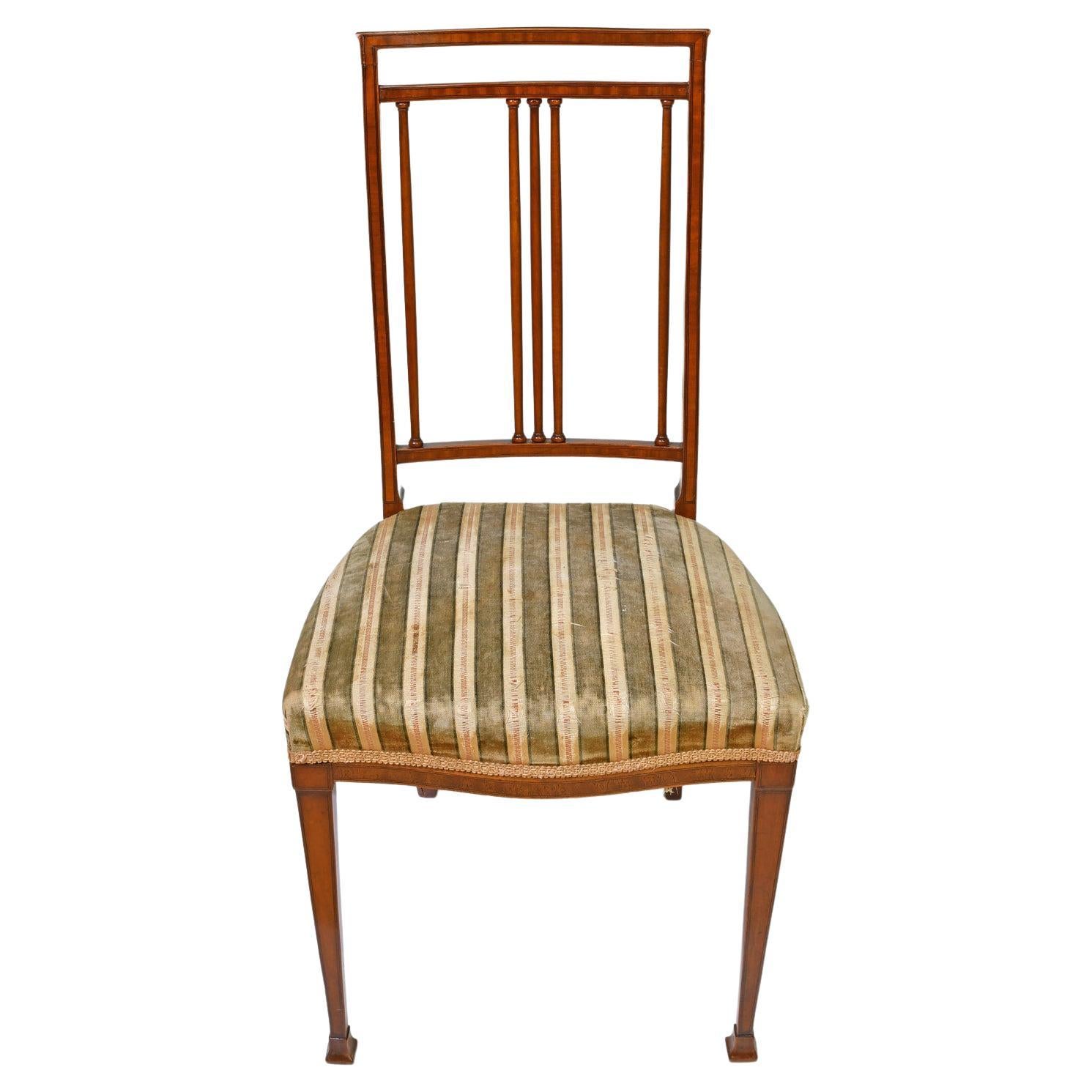 From the English Aesthetic Movement, a pair of finely-crafted side chairs in mahogany with ebonized line inlays. Featuring an exquisite choice of woods with concave high back with three finely-turned vertical columns along the center between