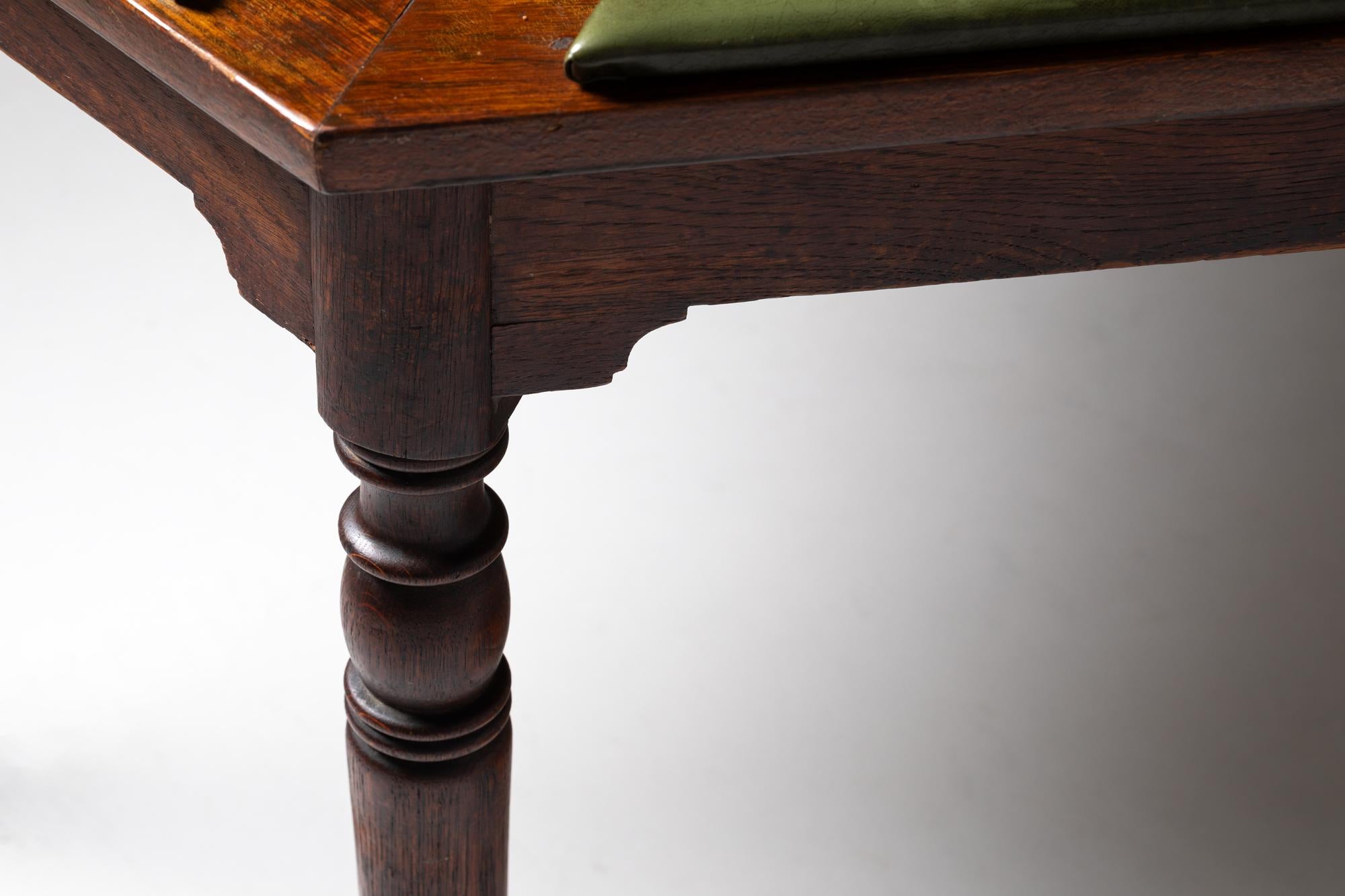 Hex Game Table is a hexagon-shaped gaming table with wood carvings, green felt top, and golden bronze ashtrays. It has green leather armrests for greater comfort during games. This particular table is an antique nineteenth-century piece that was
