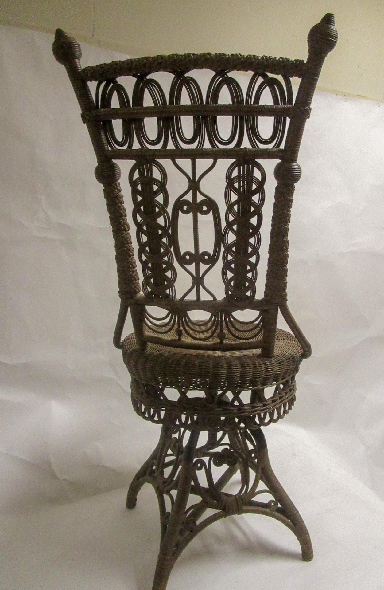 This fanciful Victorian wicker swivel piano chair has all the bells and whistles of the most prestigious American wicker designers Heywood Brothers and Wakefield Company. Curlicues, various intricate weaves, braiding, swags, beads and balls are the