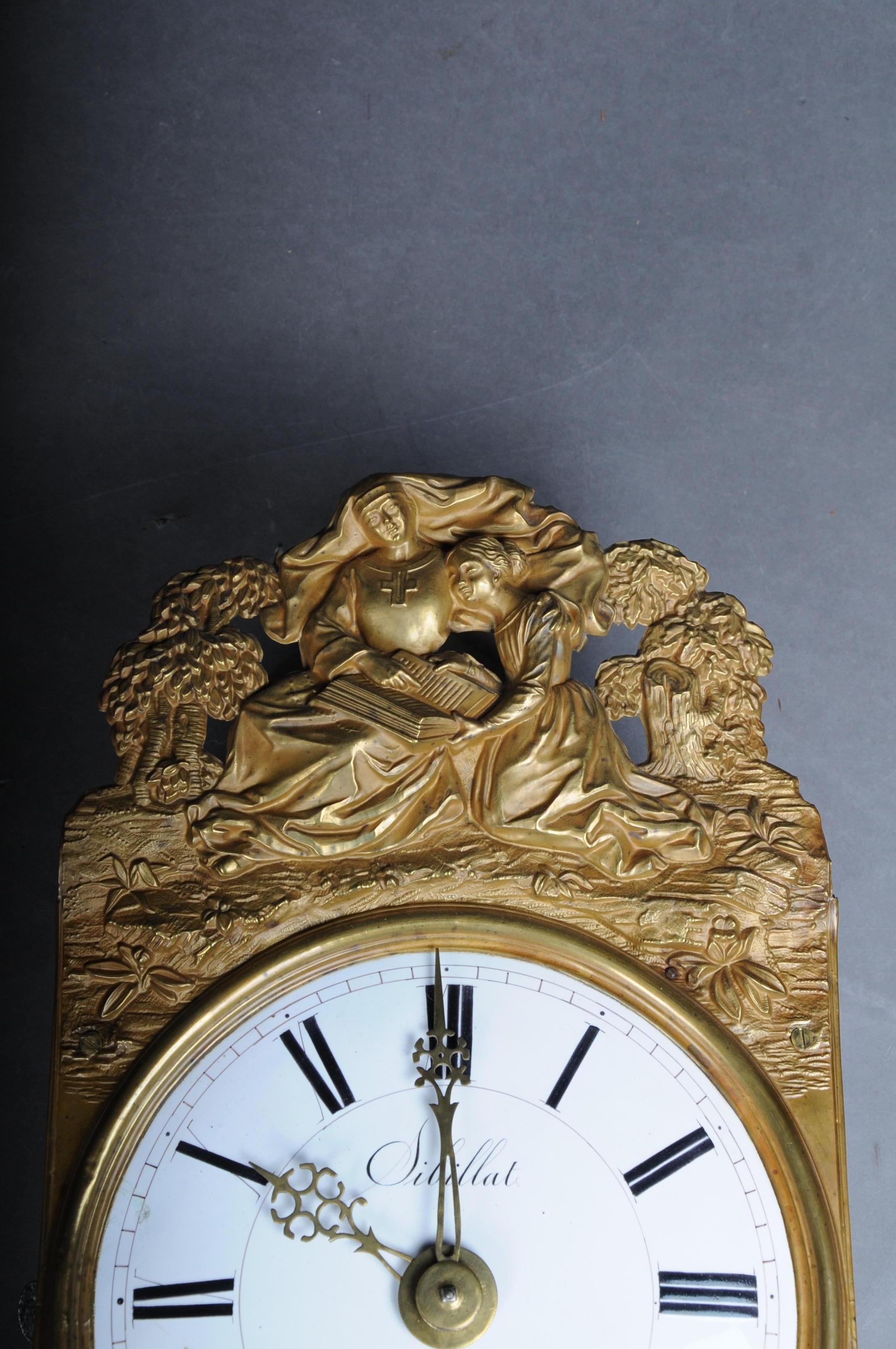 High quality originals Comtoise / wall clock brass

Heavy, high quality Comtoiser watch movement.
A beautiful antique original French wall clock (Comtoise).
Enamelled dial pendulum and 2 weights the border is made of stamped brass sheet is in