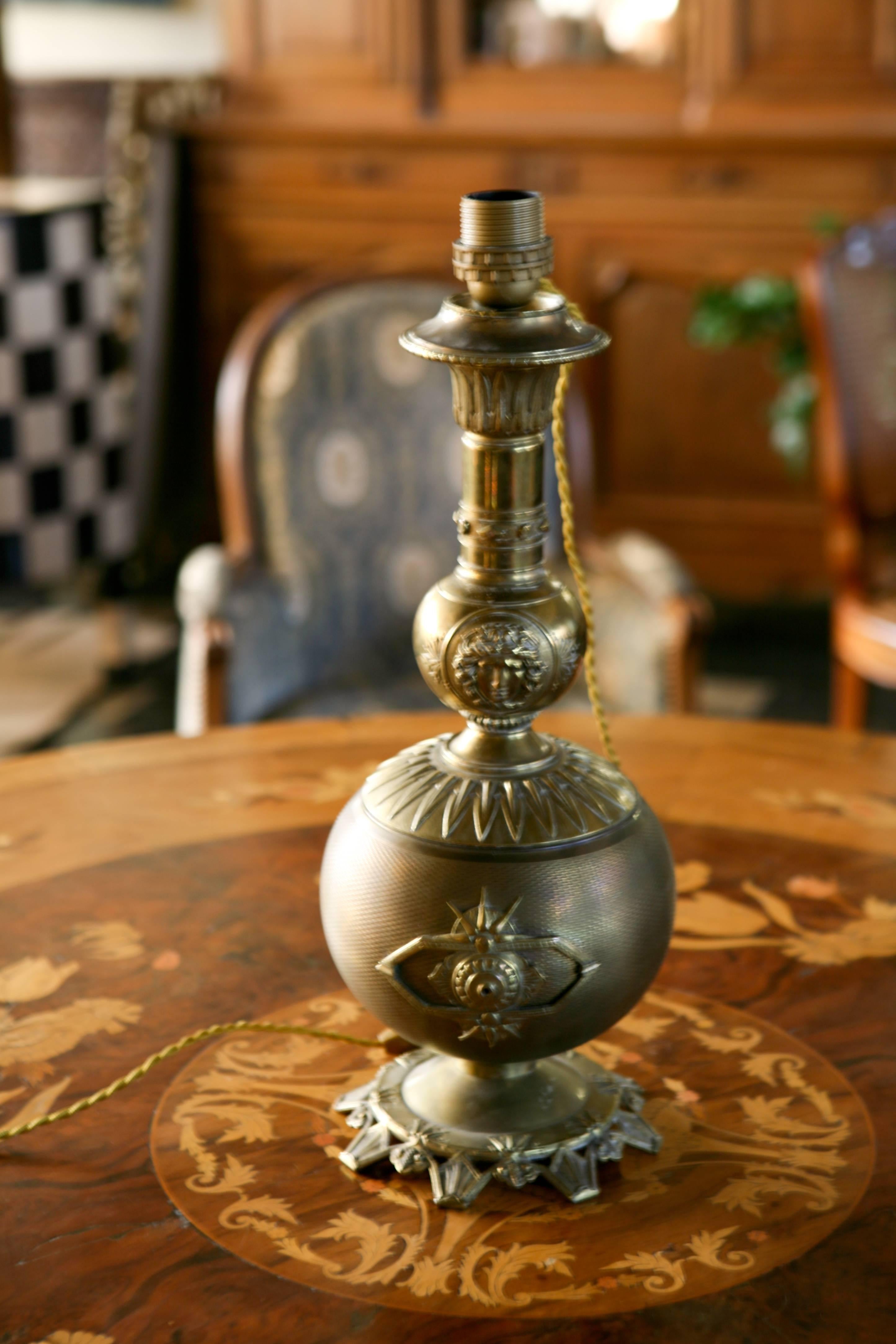 Oil lamp mounted in electric lamp, brass decorated with a woman's head in a medallion,
France, circa 1860.