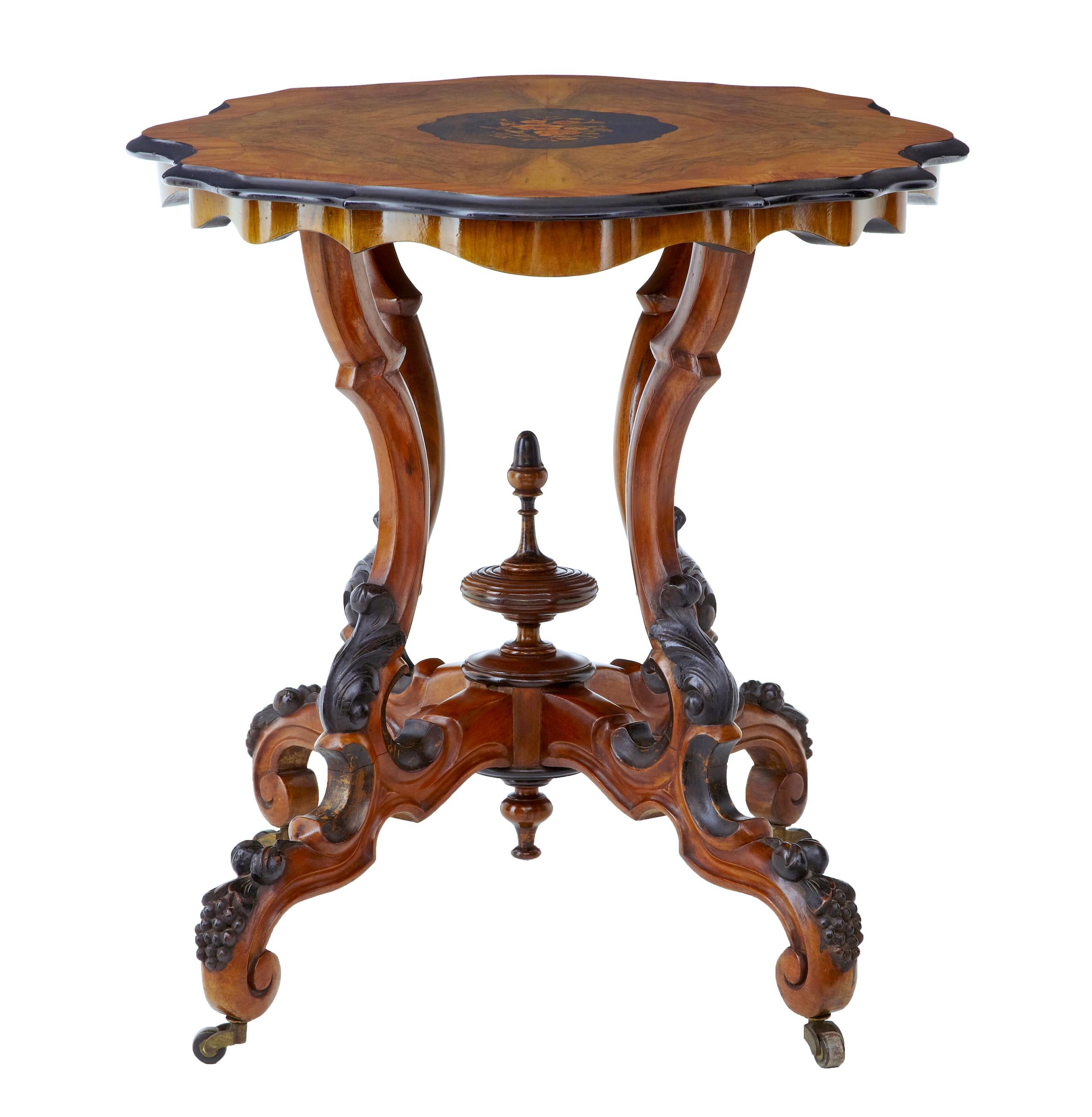 Fine quality walnut inlaid occasional table, circa 1870. Central inlaid floral section, using birch and walnuts veneers. Walnut top crossbanded in satinwood with ebonised shaped edging. Stands on 4 shaped legs with applied acanthus leaves and fruit