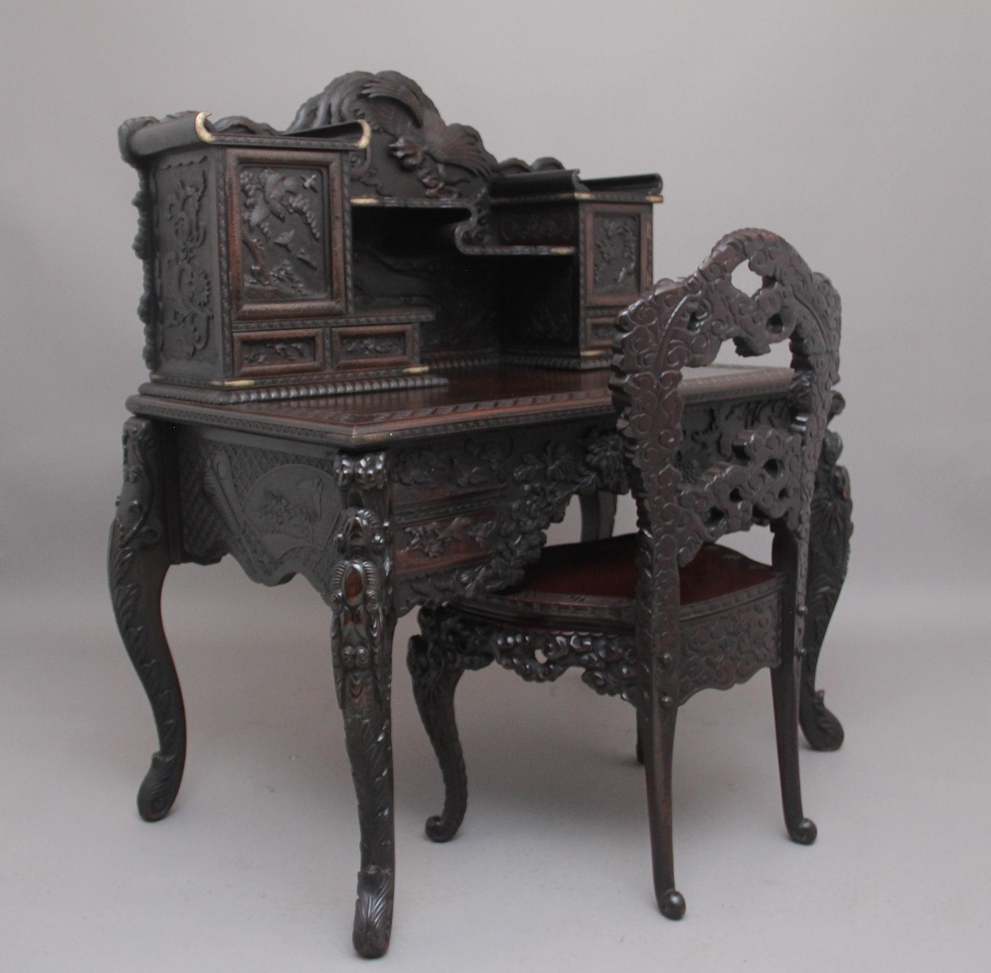 19th century highly carved Japanese writing desk and chair from the Meiji period, the desk comprising of two sections, the top section having a shaped back incorporating a flying mythical bird above shaped shelves with scroll ends with brass