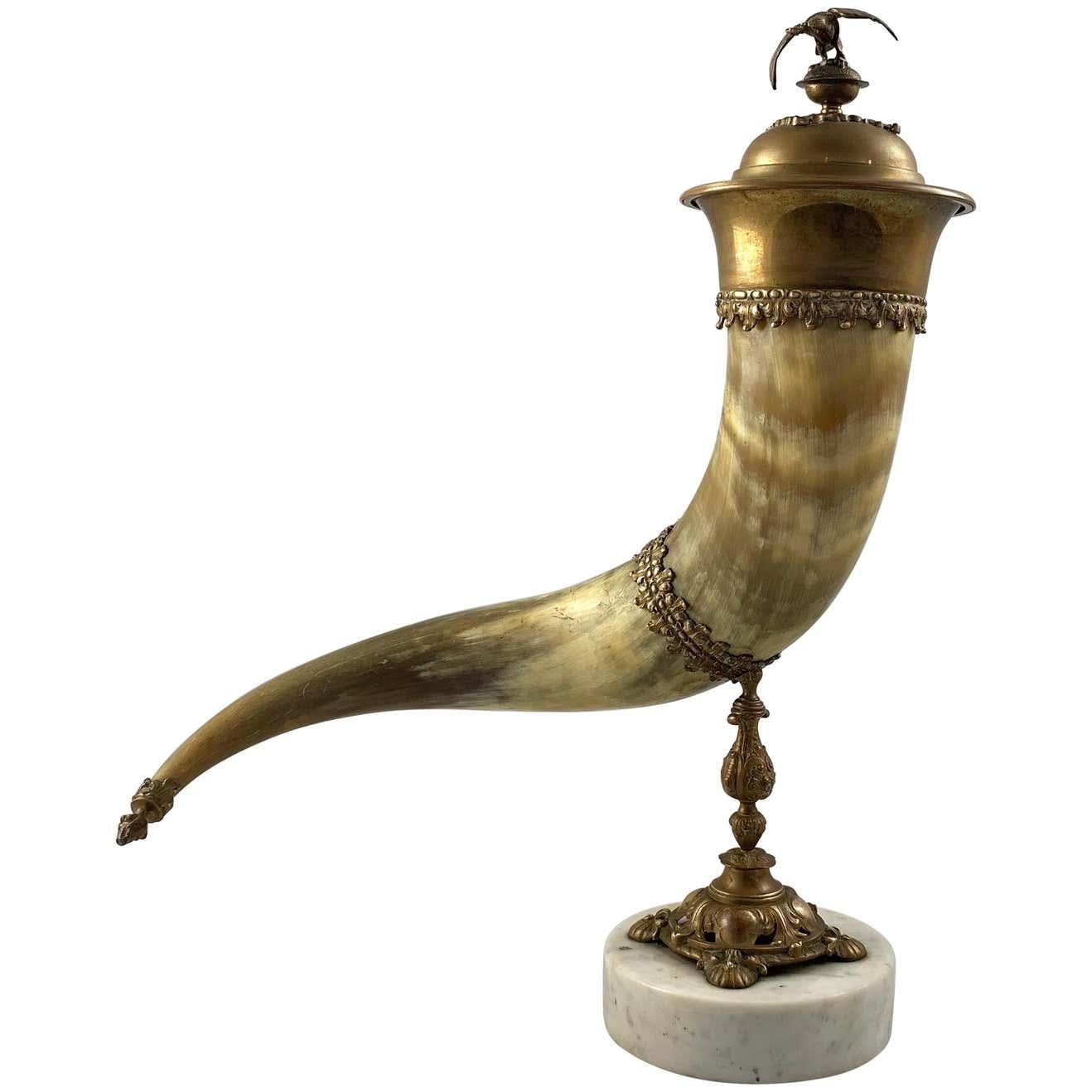 Une corne d'abondance finement montée en corne et laiton doré avec couvercle.

19ème siècle.

Supporté par un pied en fonte sur une base carrée.