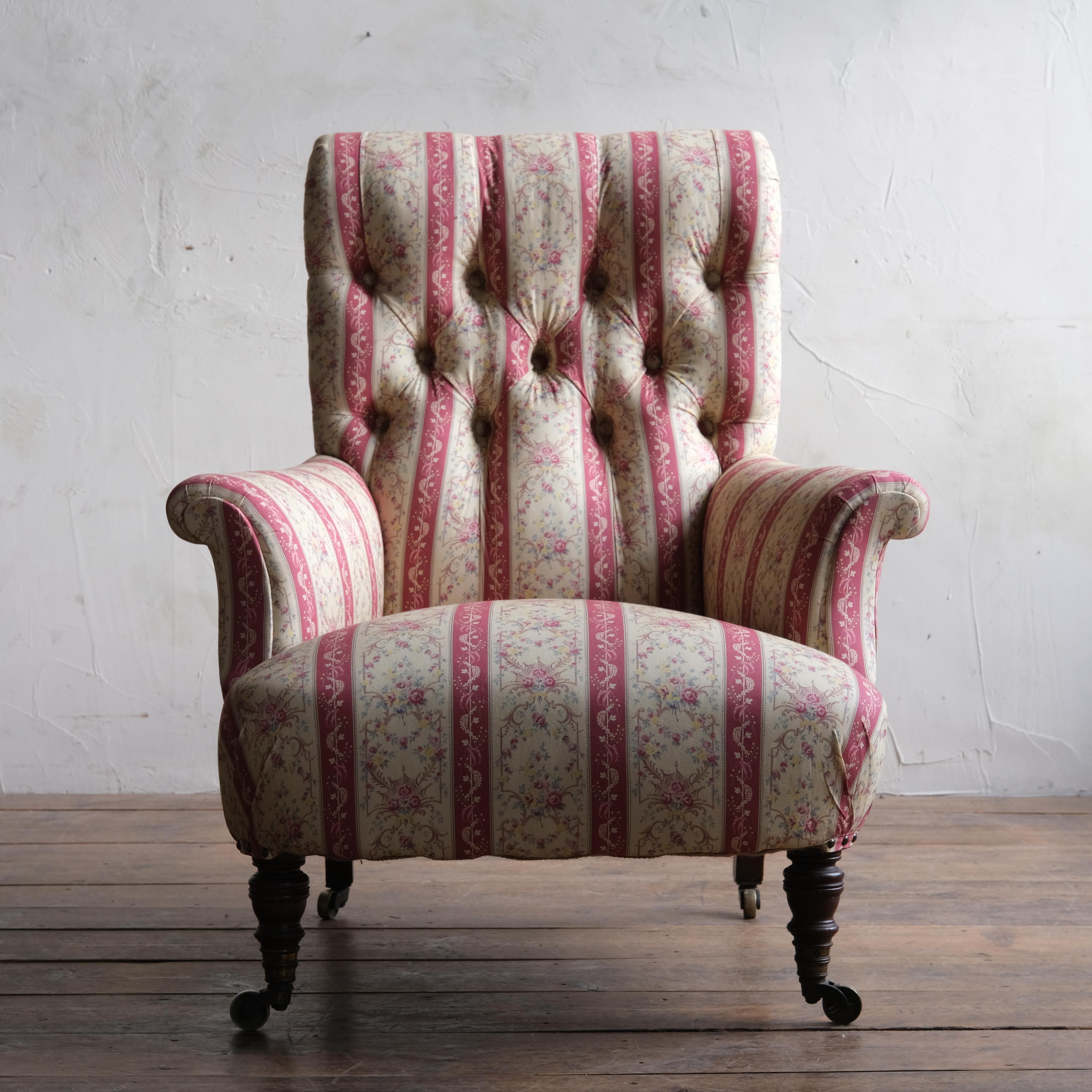 A 19th Century Howard & Sons 'Hammond' armchair raised on walnut turned legs to the front without splayed legs to the rear and all with the original H&S stamped brass casters.

Newly upholstered in H&S red strip under lining ready for your choice