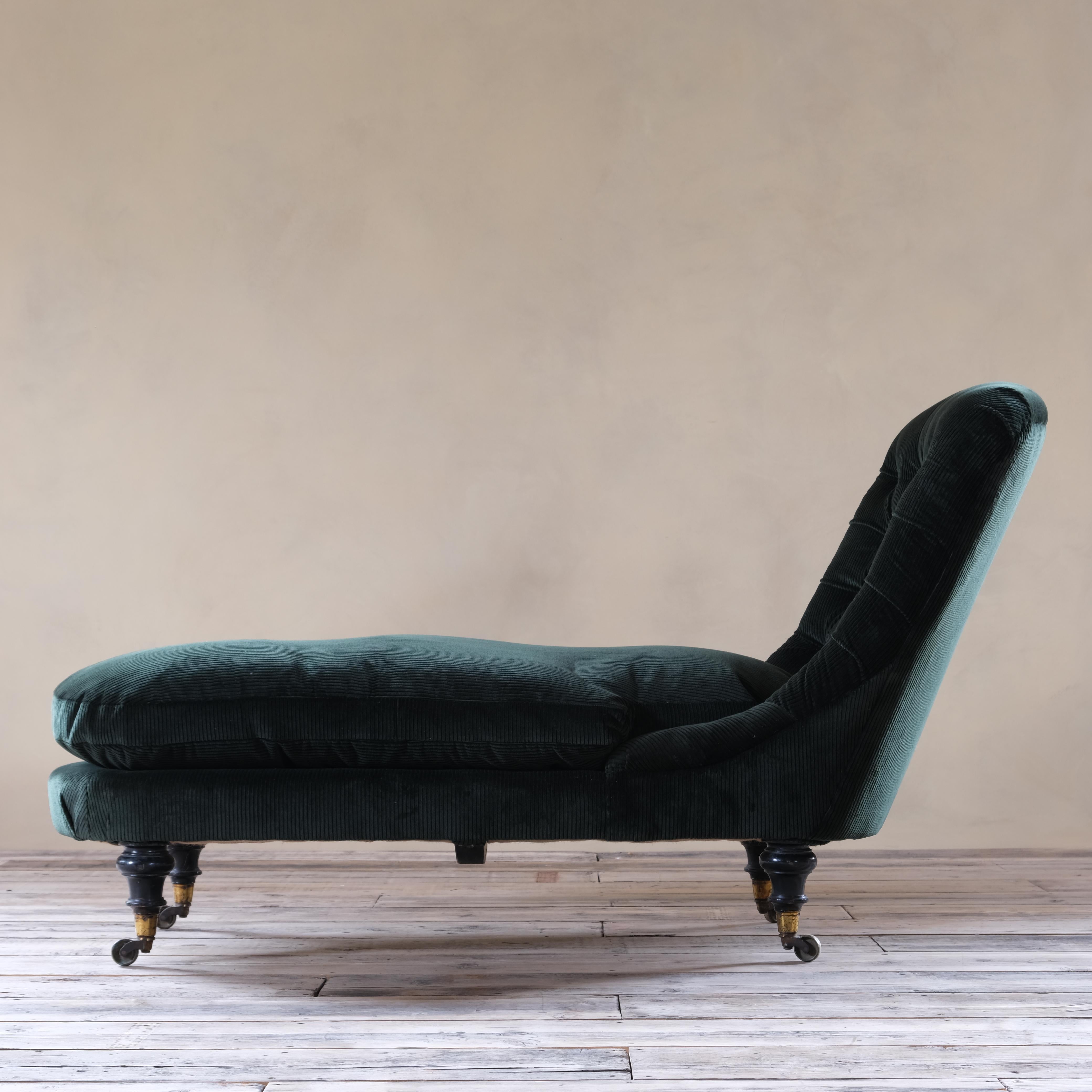A mid 19th century daybed by Howard and Sons - London. Raised on 4 ebonized turned walnut legs and the original gilt brass Cope & Collinson brass casters.
Upholstered in Forest green jumbo cord by Rose Uniacke with a plum feather filled