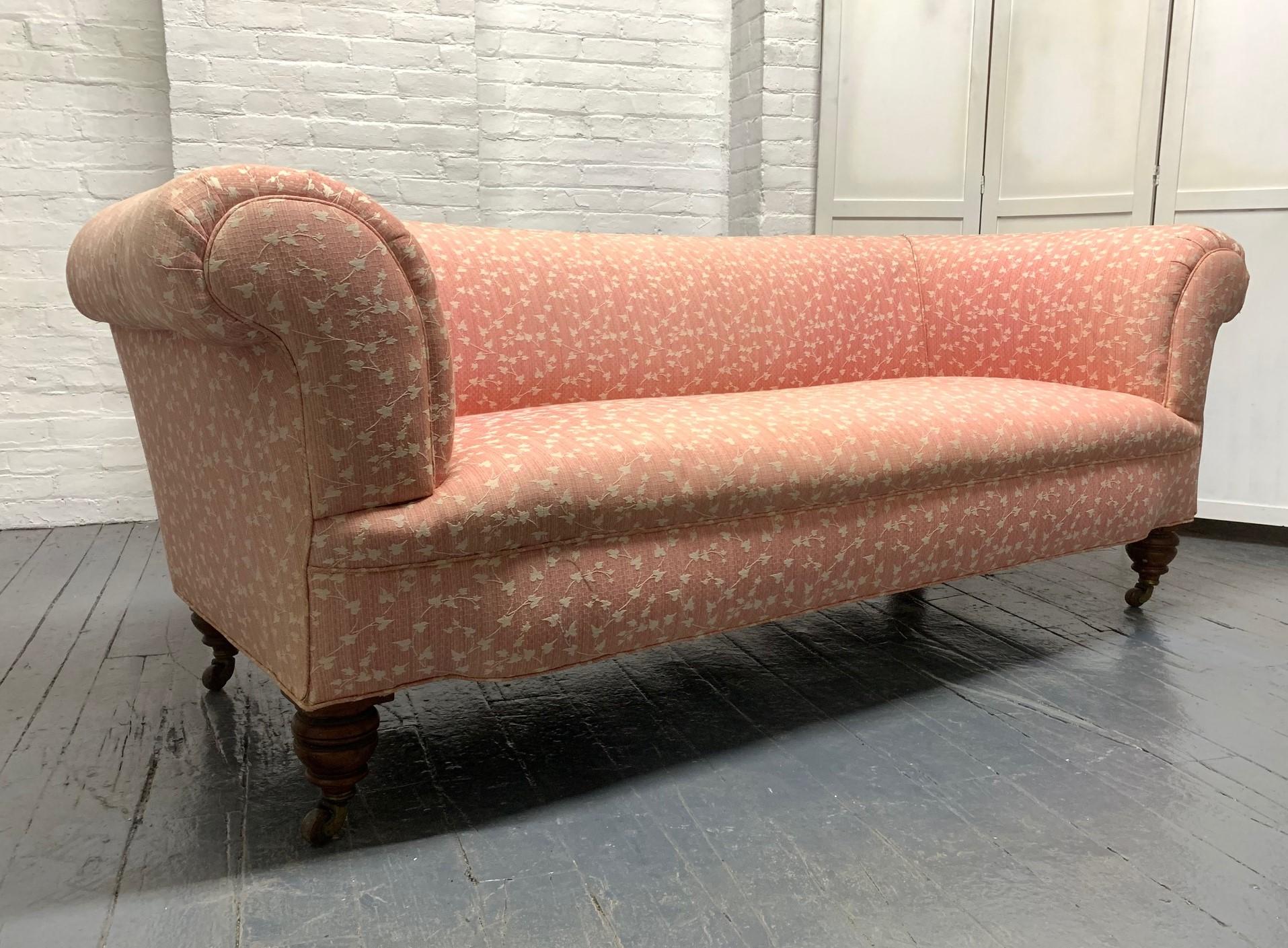 19th century Howard and Sons sofa having rolled arms and turned walnut legs on casters. 