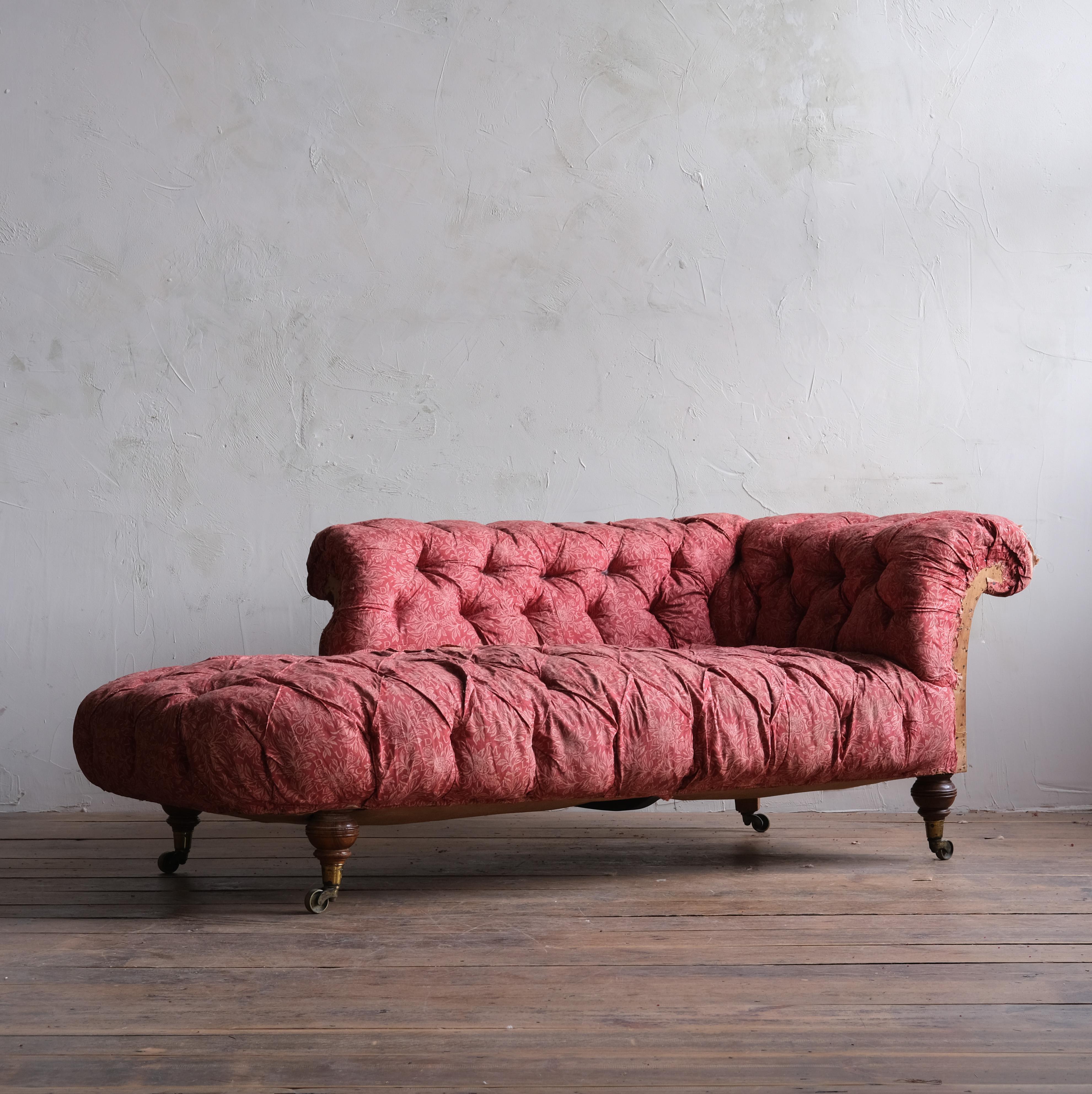 A very good quality chaise lounge by Howard & Sons - London. Raised on walnut ring turned legs with the original gilt brass cup casters. Shown here in its original under lining ready for a new top cover. The stuffing is in great order and the piece