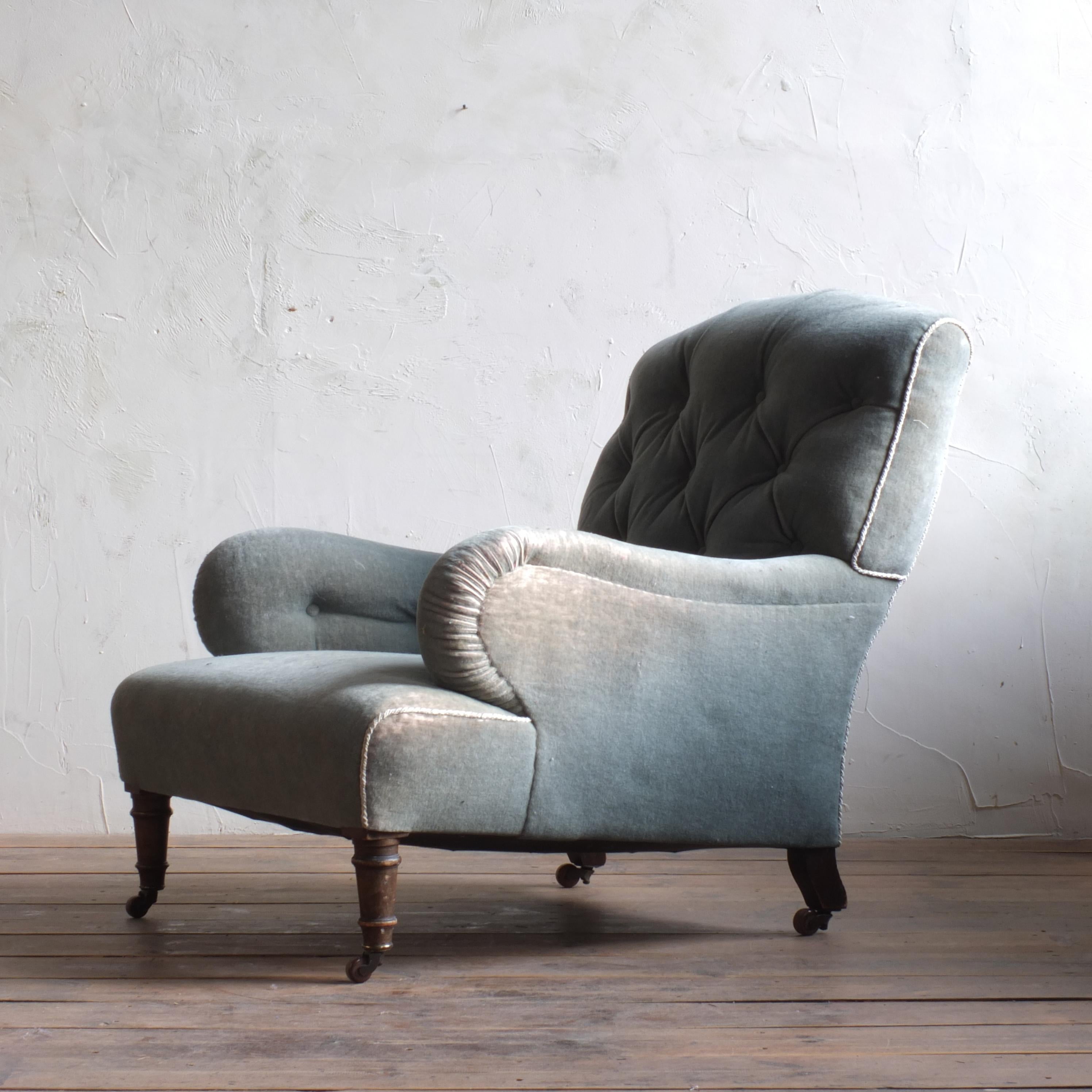 A large deep seated country house armchair in the manner of Howard and sons. Currently upholstered in pale blue velvet that is thread bare in places. The chair is advertised as in need of upholstery however is more than liveable and very