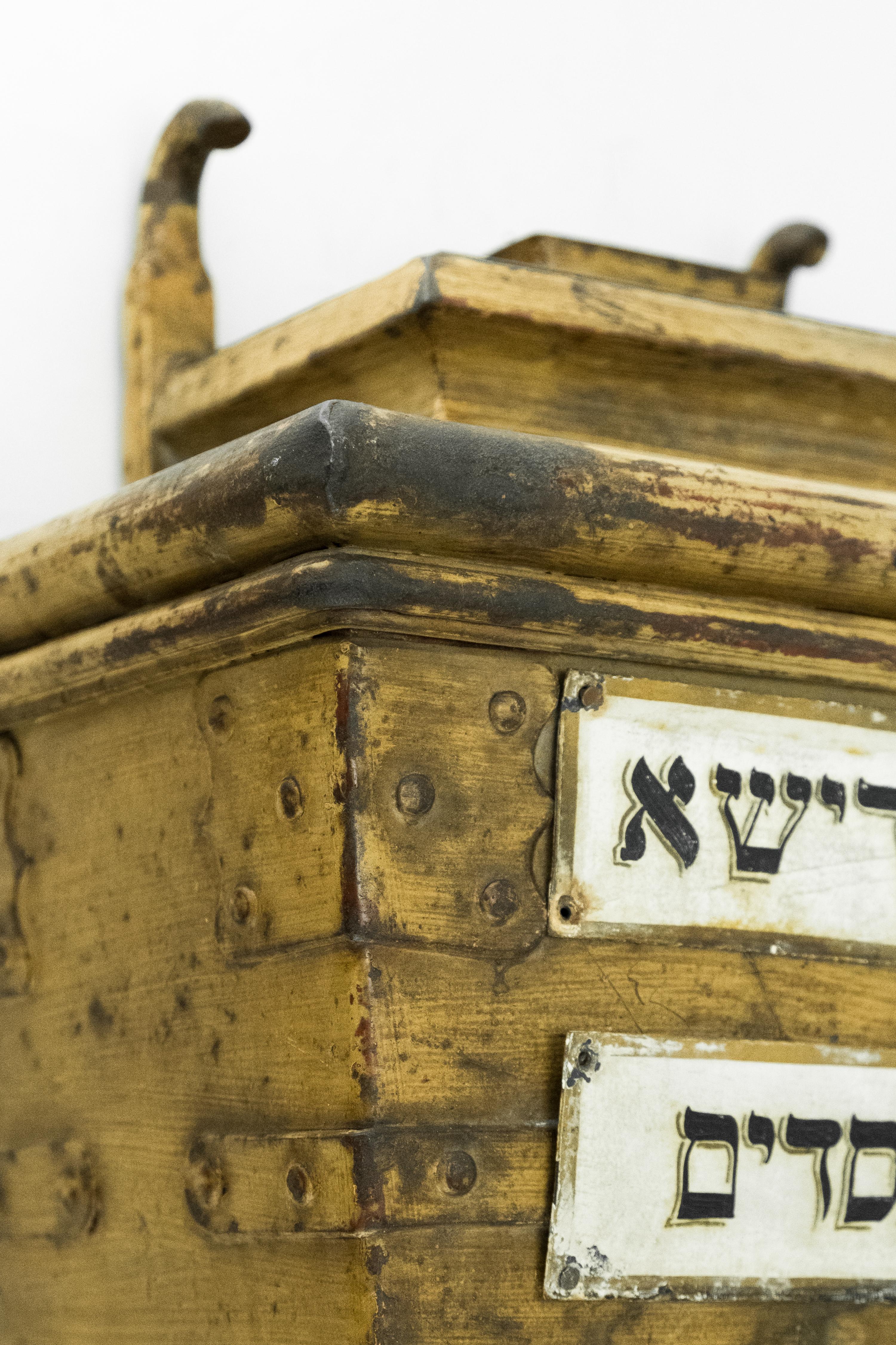 Großer handgefertigter eiserner Almosenbehälter, Ungarn, um 1850.
Die eiserne Tzedakah-Box wurde in der Mauer der ungarischen Synagoge installiert.
Auf der Vorderseite befinden sich zwei Metalltafeln mit der hebräischen Aufschrift 
