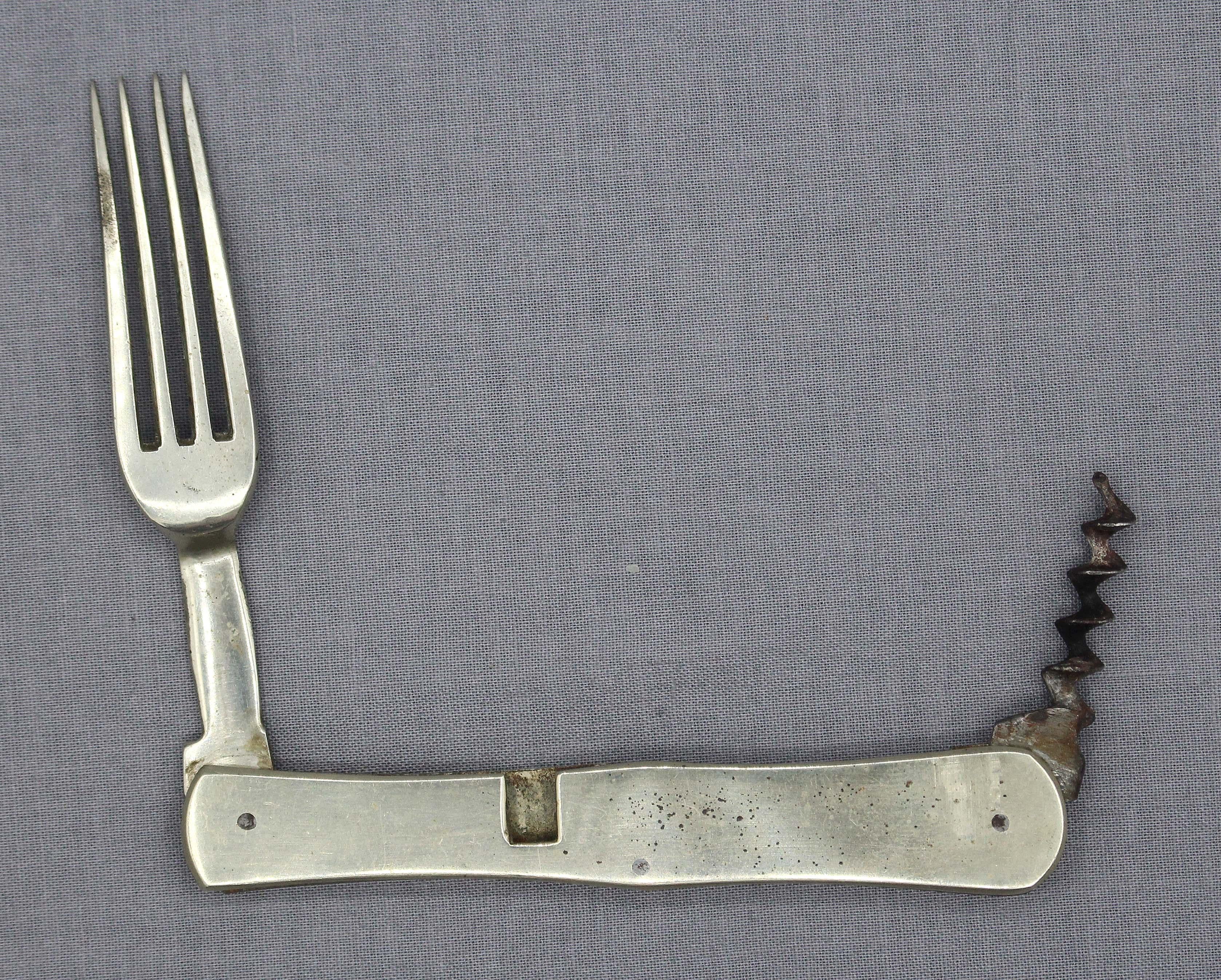 Tenedor plegable de viaje y sacacorchos de cazador o soldado del siglo XIX, probablemente inglés. Tenedor plegable de viaje de 4 púas y sacacorchos de plata y acero, sin marcar. Una pieza robusta pensada para un uso duro y una larga vida. 1,60 onzas