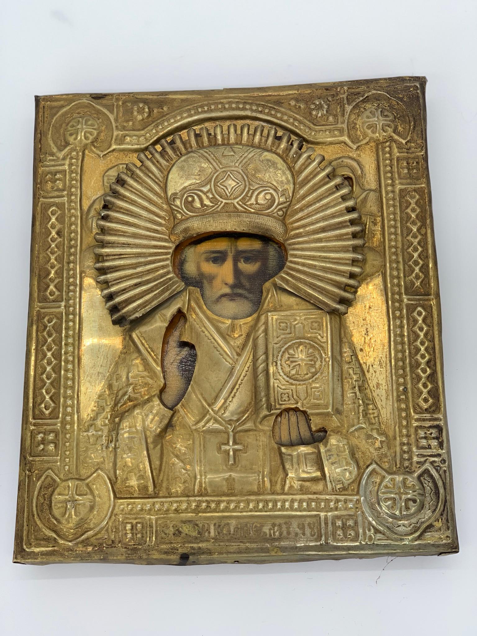 Belle icône en laiton doré d'un évêque avec auréole et peinture sur bois.