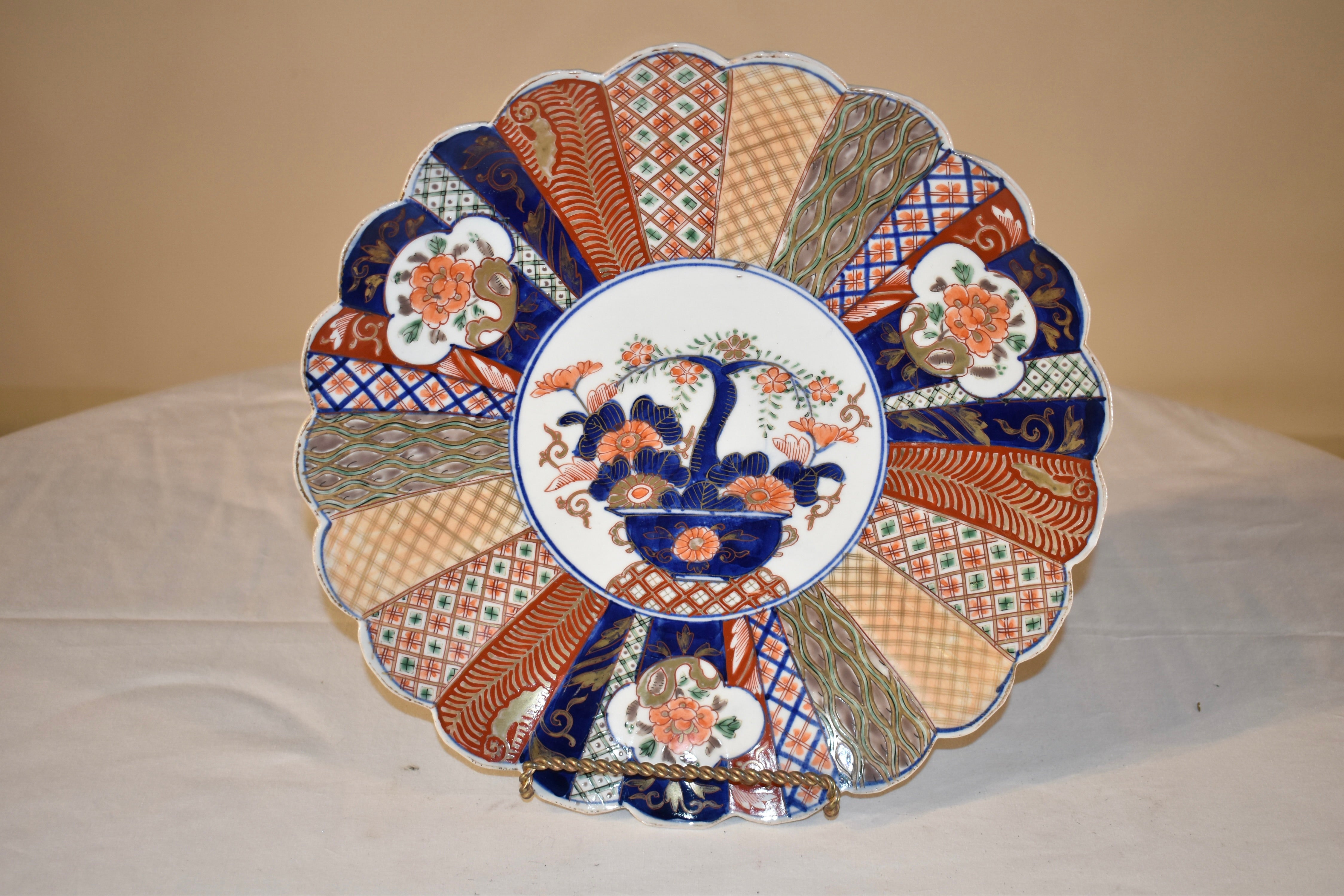19th century Imari charger with exquisitely hand painted patterns in lovely colors. There is a central medallion, which depicts what appears to be a jade tree, surrounded by florals. The central medallion is surrounded by a fan pattern of different