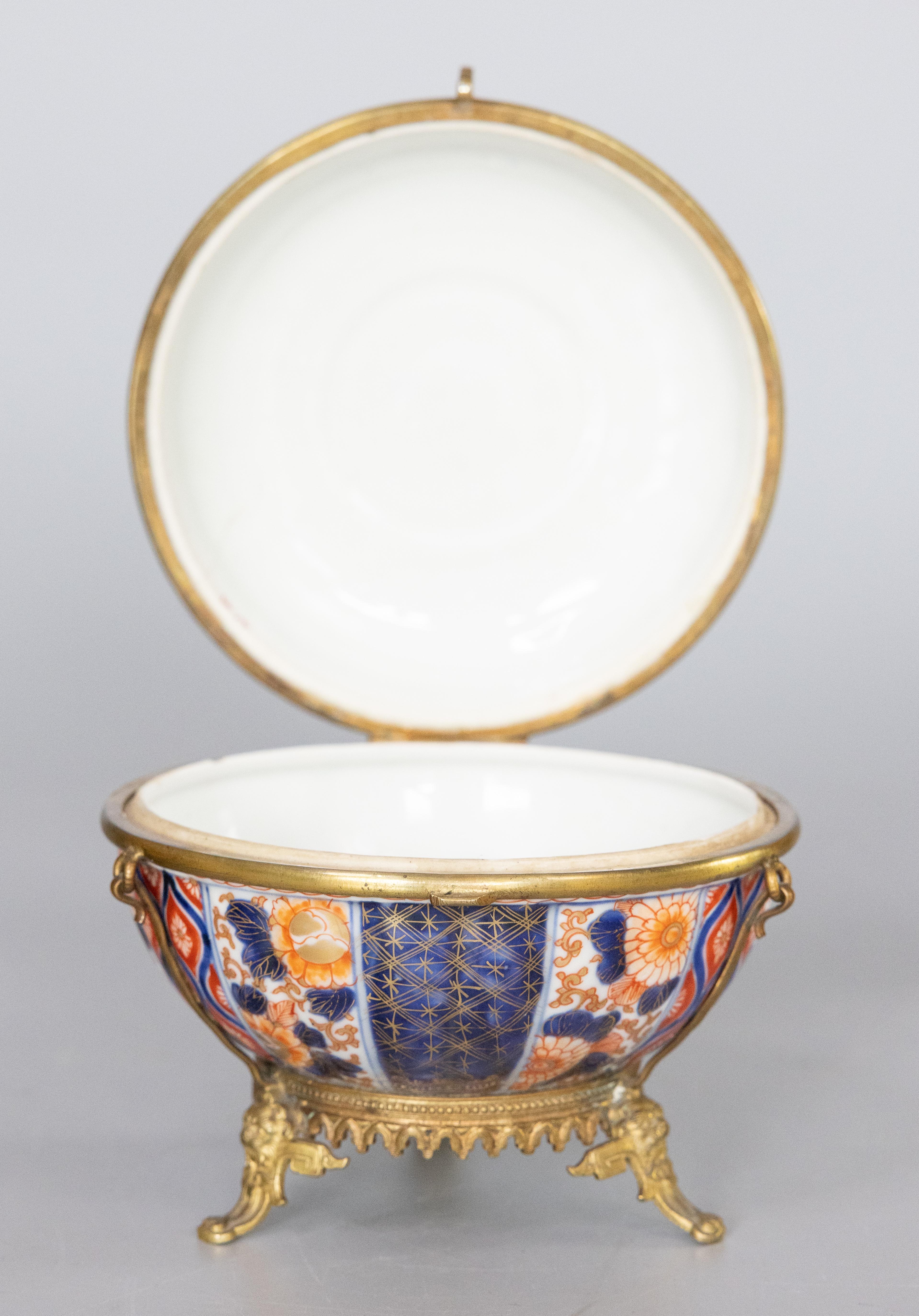 A fine and rare lidded and hinged Imari bowl with ormolu fittings, set atop three ornamented feet. Perfect for jewelry, trinkets, or sweets.