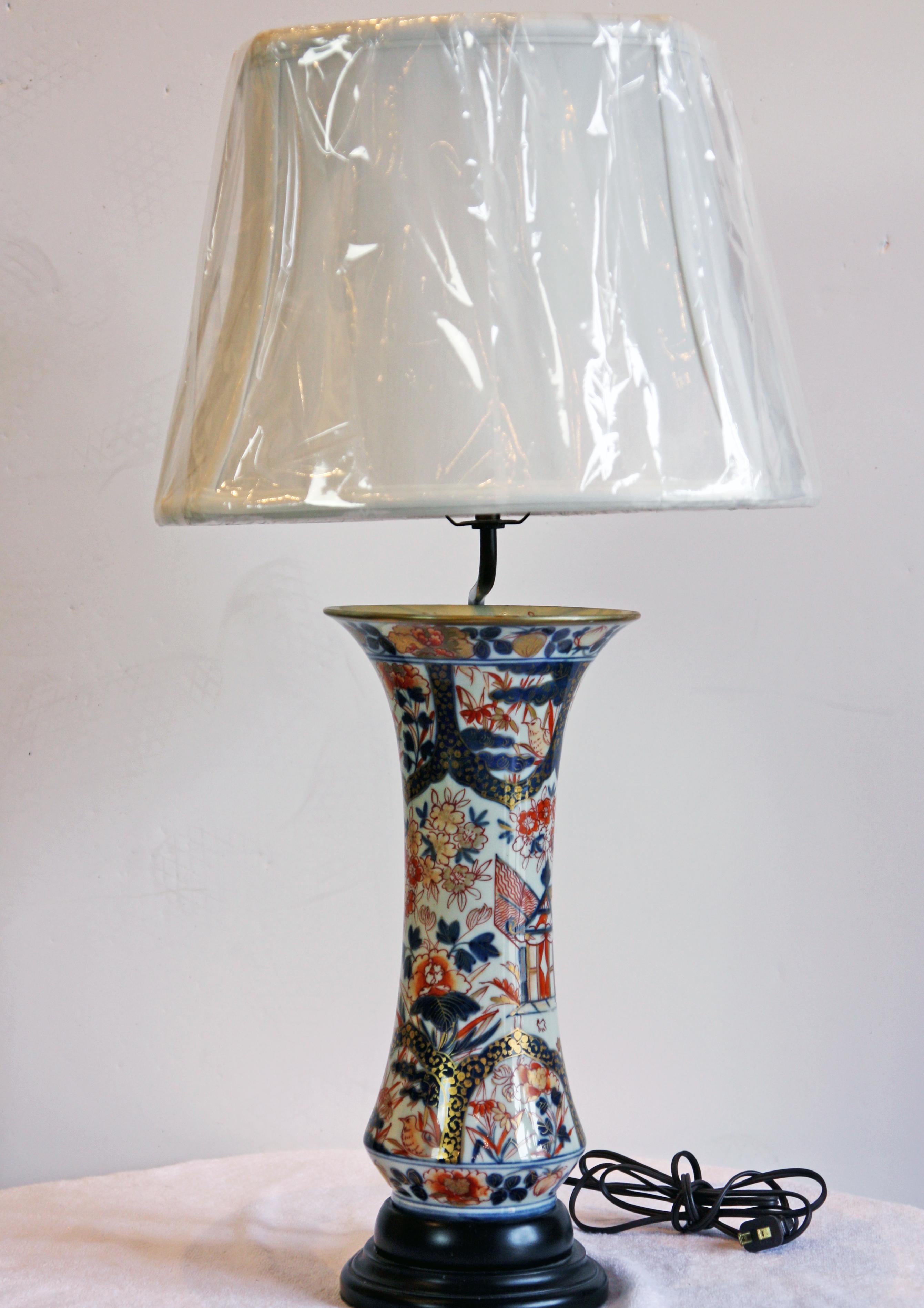 Beautiful blue, white and red Imari vase as a lamp. Hand-painted birds and flowers adorn the piece. The vase is not drilled and is removable from the lamp stand. Shade is included.