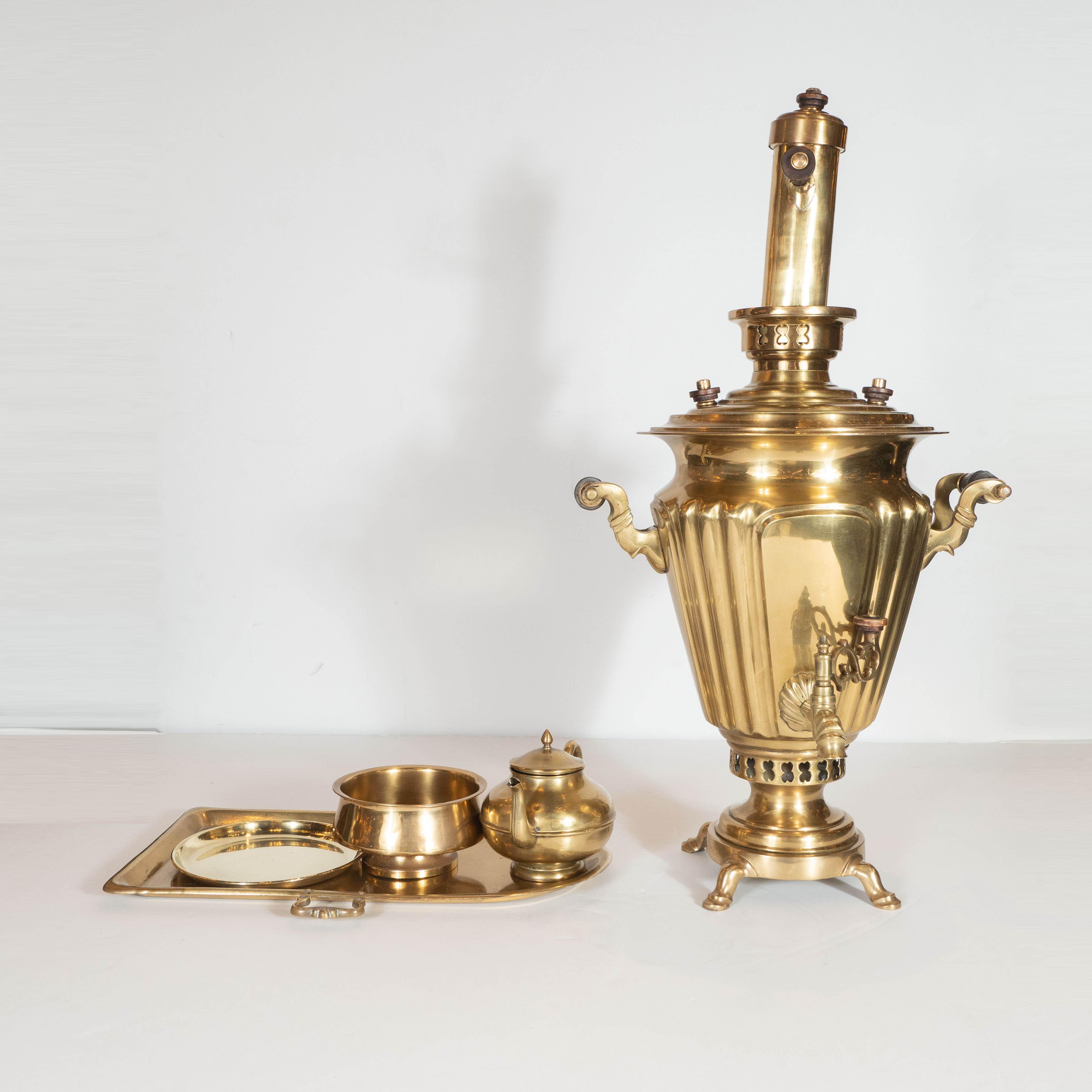 This elegant and baronial six piece brass Samovar was realized in Moscow, Russia by the esteemed maker Alenchikov & Zimin, circa 1872. It features a classical vase shaped body; a tea pot and tea tray; a chimney; a drip pot; and a bullet form serving