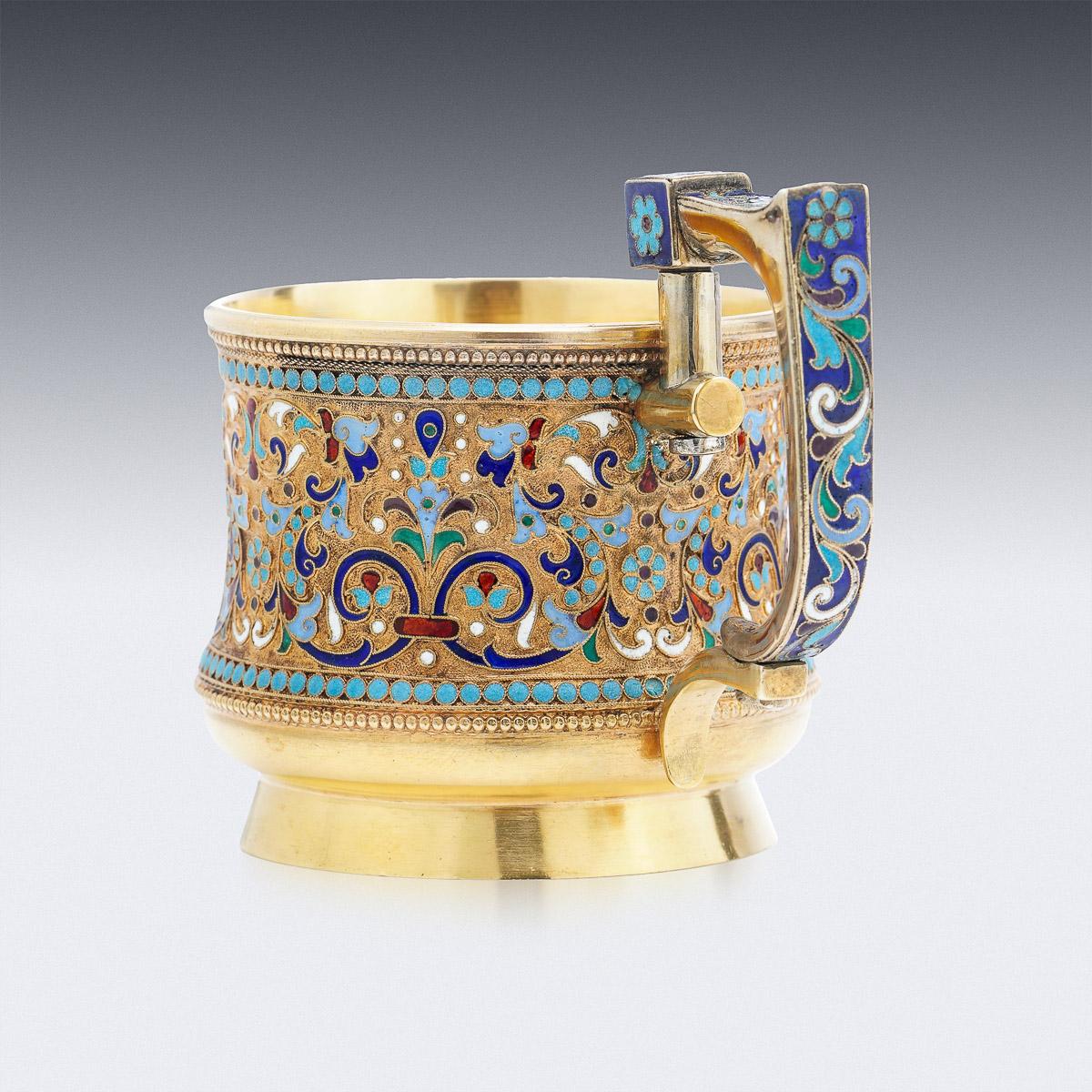 porte-verre à thé russe impérial du 19e siècle en argent doré et émail cloisonné, circulaire avec une poignée en forme de clé, un bord uni et un pied en forme de dôme, le corps est abondamment décoré de motifs floraux en émail cloisonné de couleurs