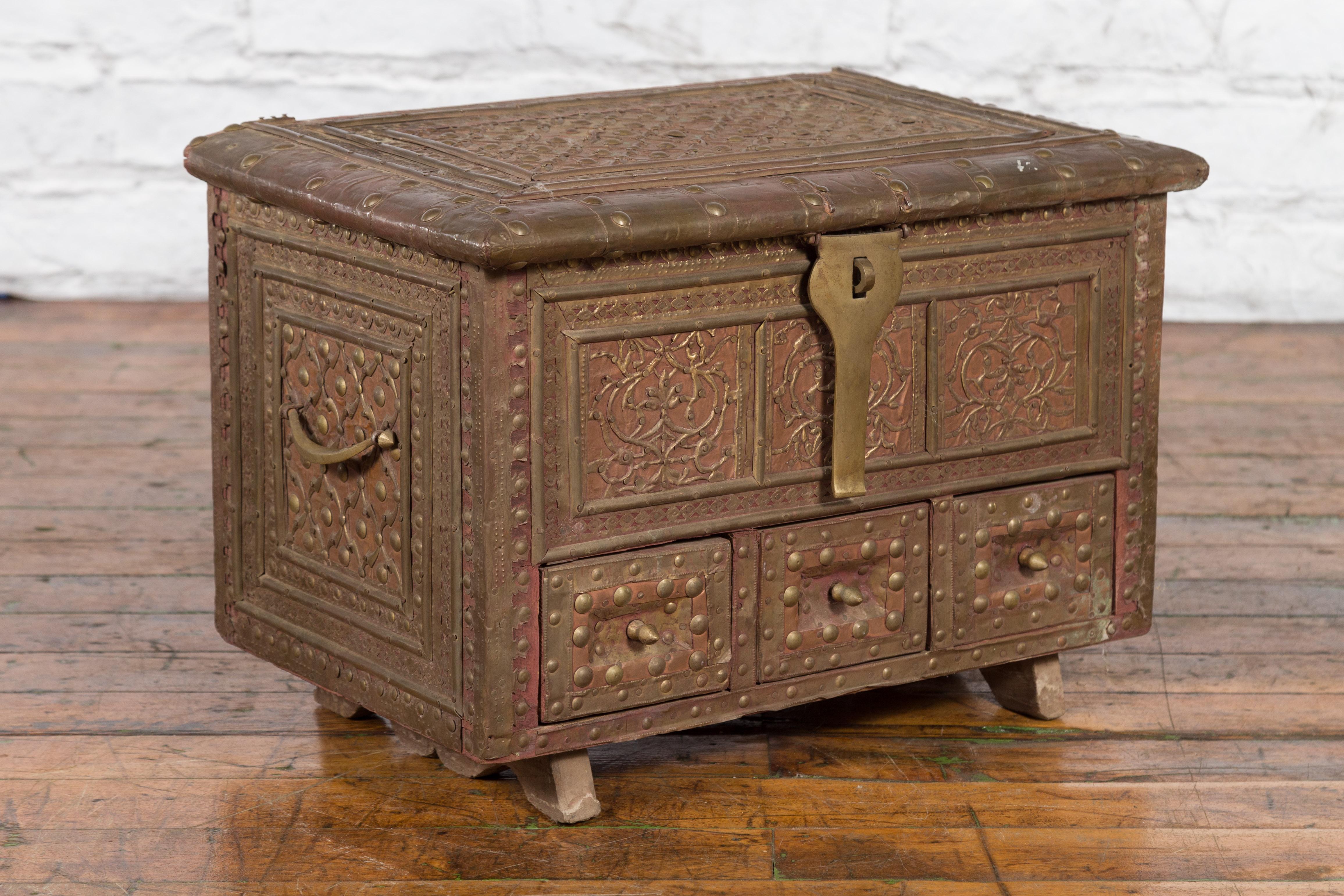 An Indian brass over wood bridal chest from the 19th century, with hand-tooled décor. Created in India during the 19th century, this bridal chest features a rectangular lid with hand-tooled brass décor, opening to reveal a convenient storage space.